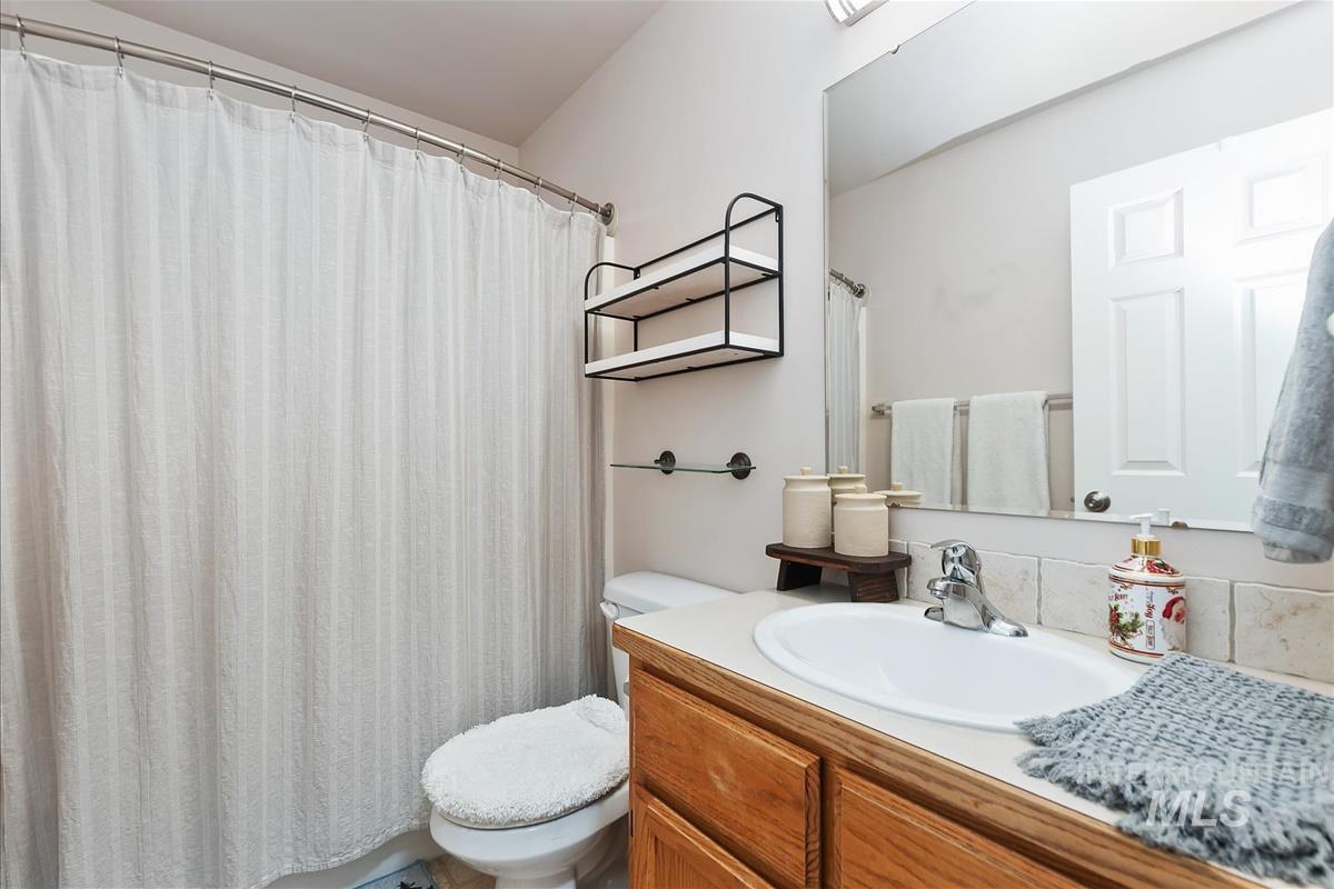 Full bath with a shower with shower curtain and vanity