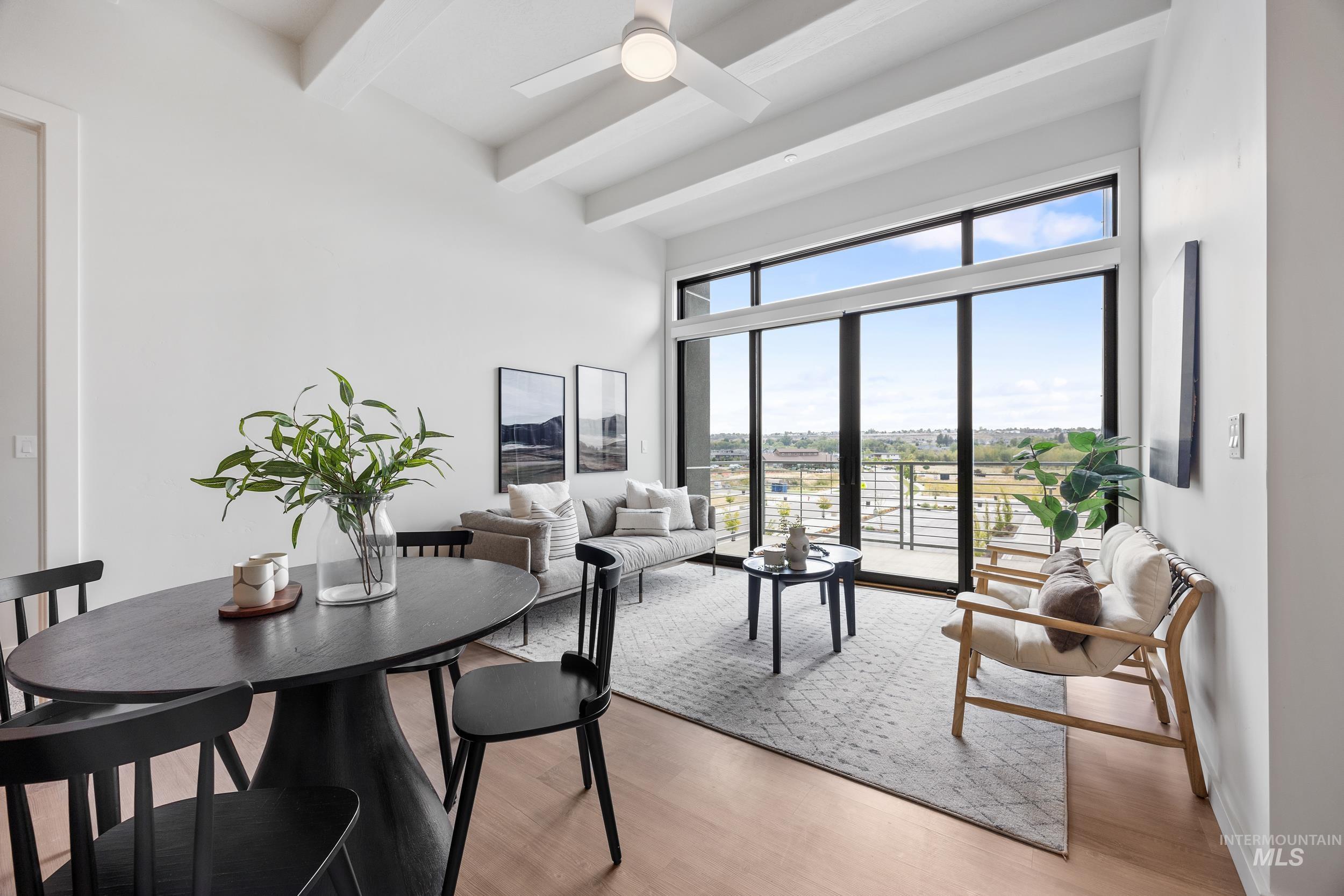 Dining area with light wood-type flooring, beamed ceiling, and a ceiling fan