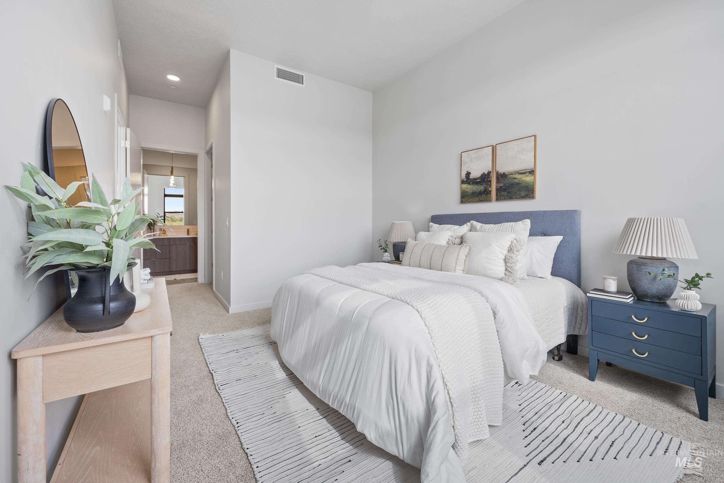 Carpeted bedroom with connected bathroom and baseboards
