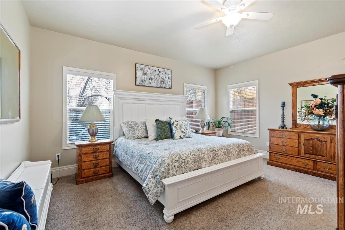 Bedroom featuring carpet flooring, multiple windows, and a ceiling fan