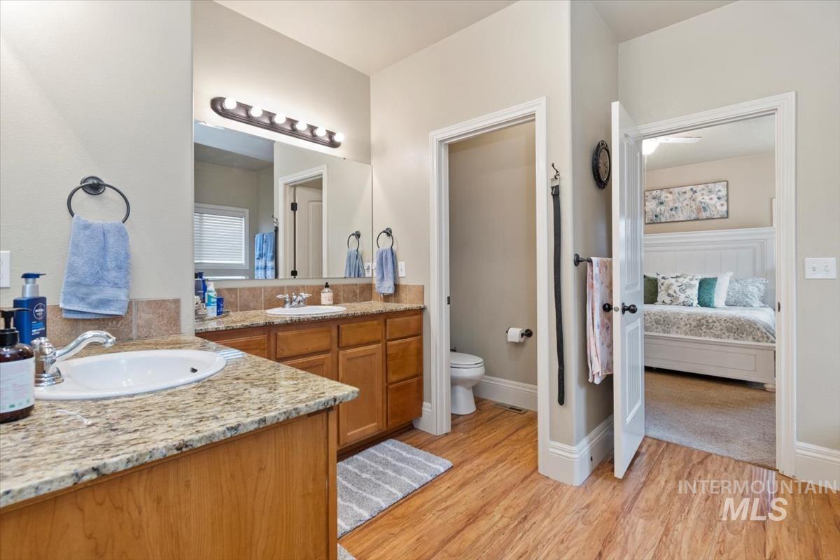Full bathroom featuring vanity, light wood-style floors, and connected bathroom
