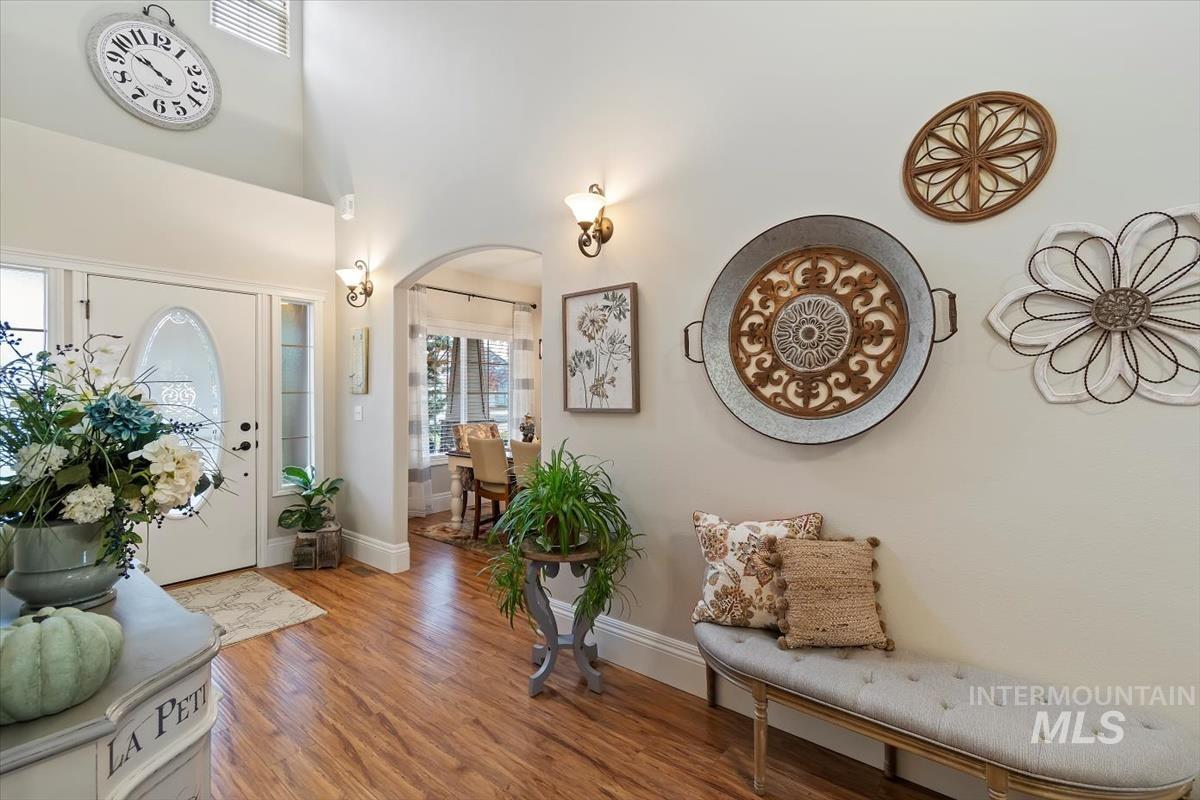 Foyer entrance featuring arched walkways, wood finished floors, and a high ceiling