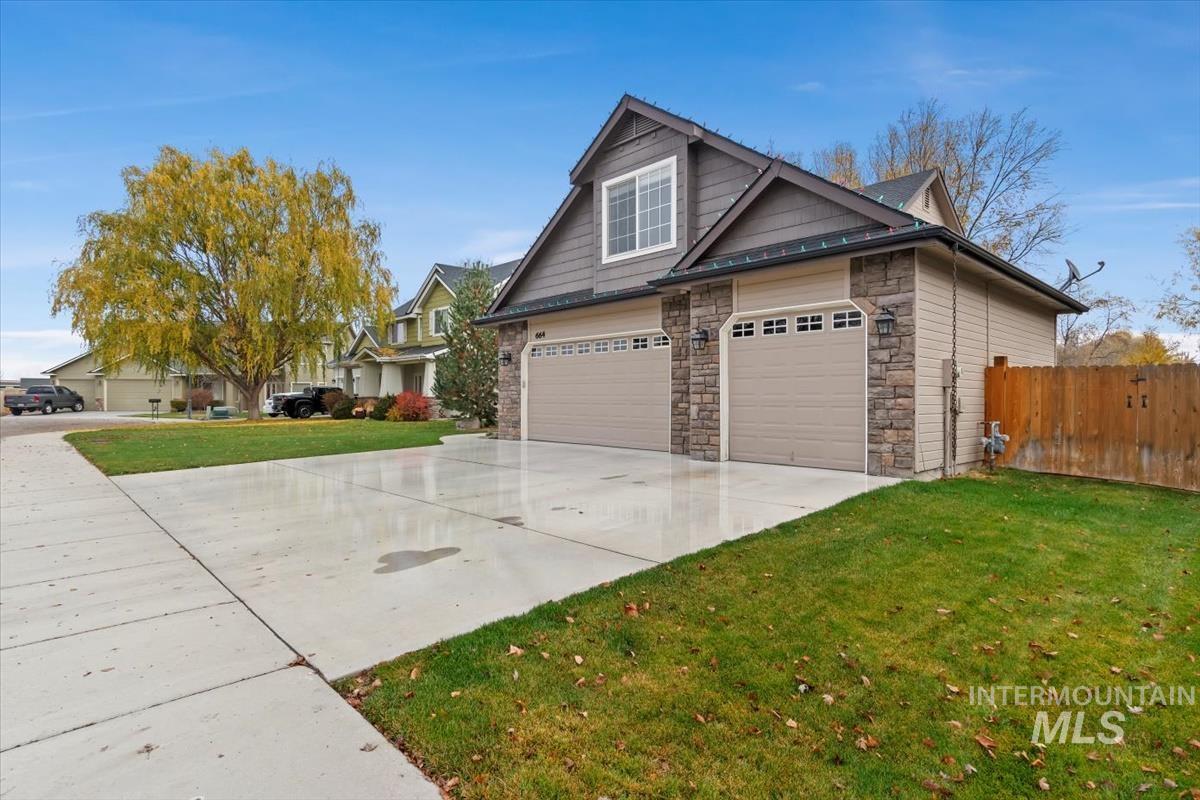 View of side of home featuring concrete driveway and stone siding