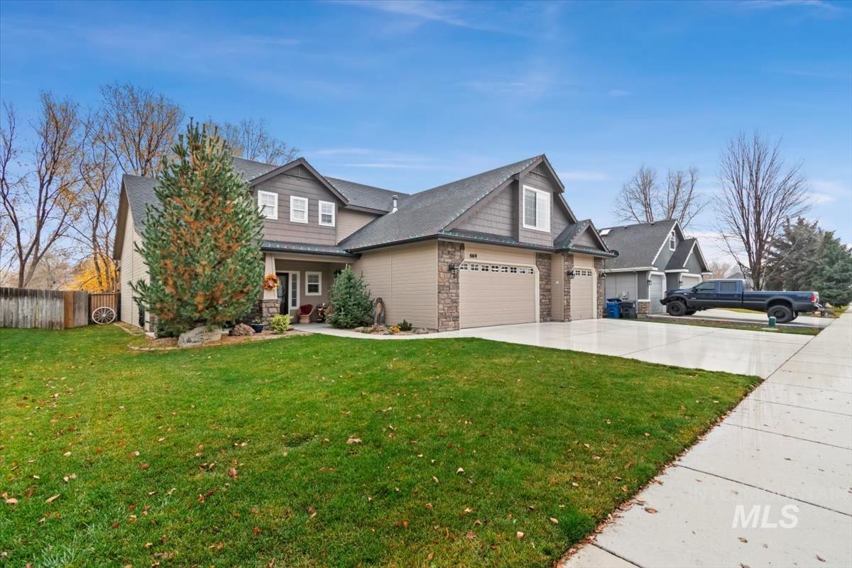 Craftsman-style house featuring concrete driveway, stone siding, and a garage