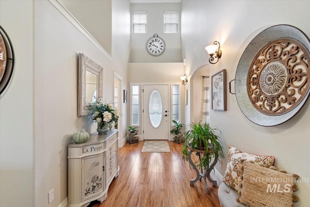 Entryway with a towering ceiling, plenty of natural light, and wood finished floors
