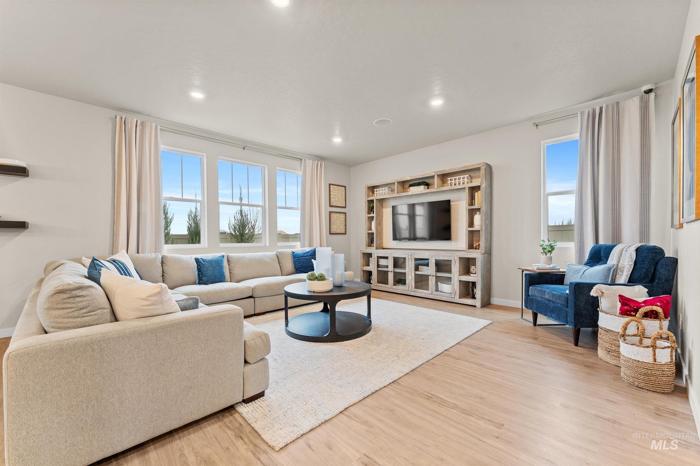 Living room with healthy amount of natural light, light wood-style flooring, and recessed lighting