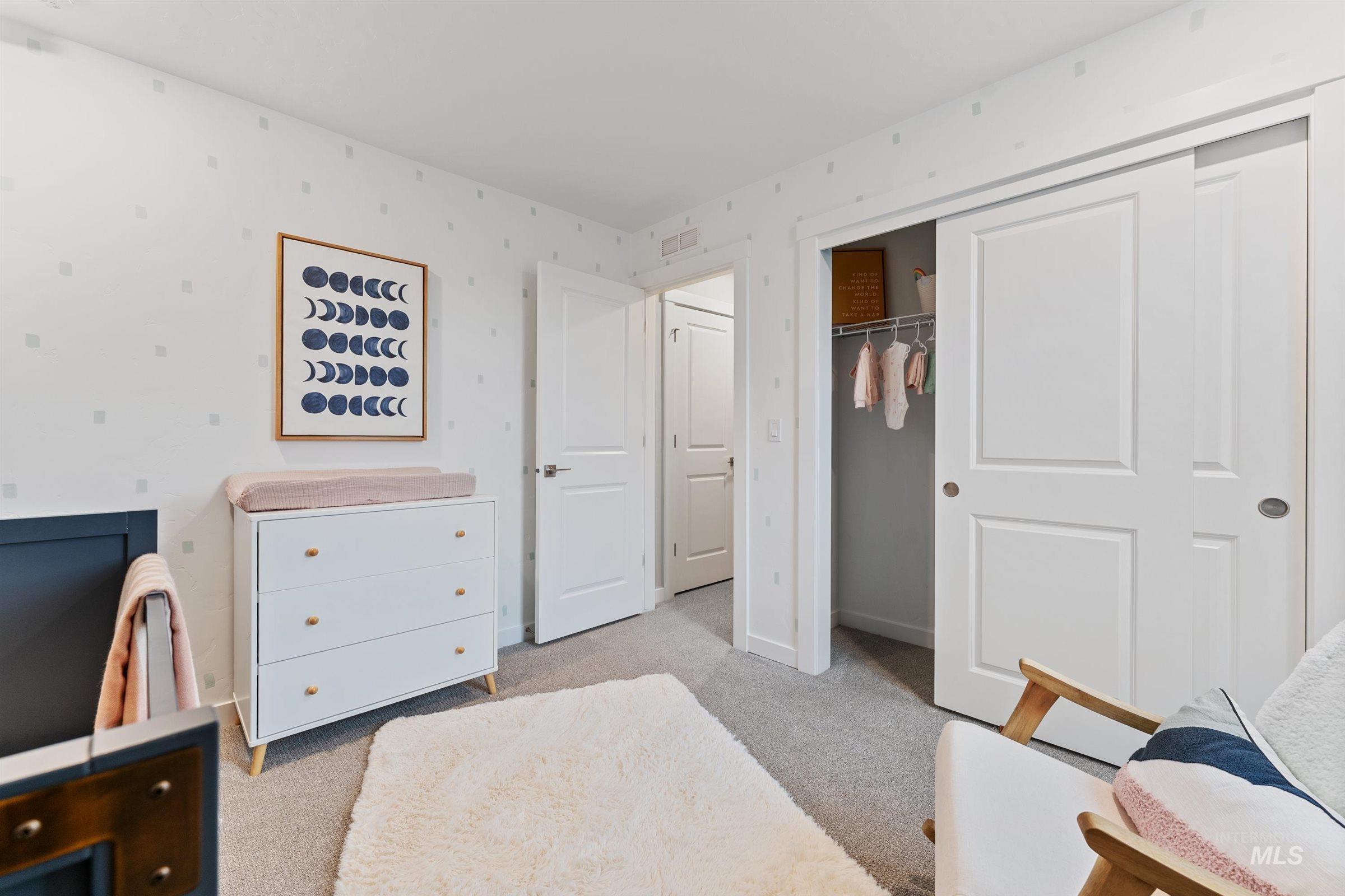 Bedroom with light colored carpet and a closet