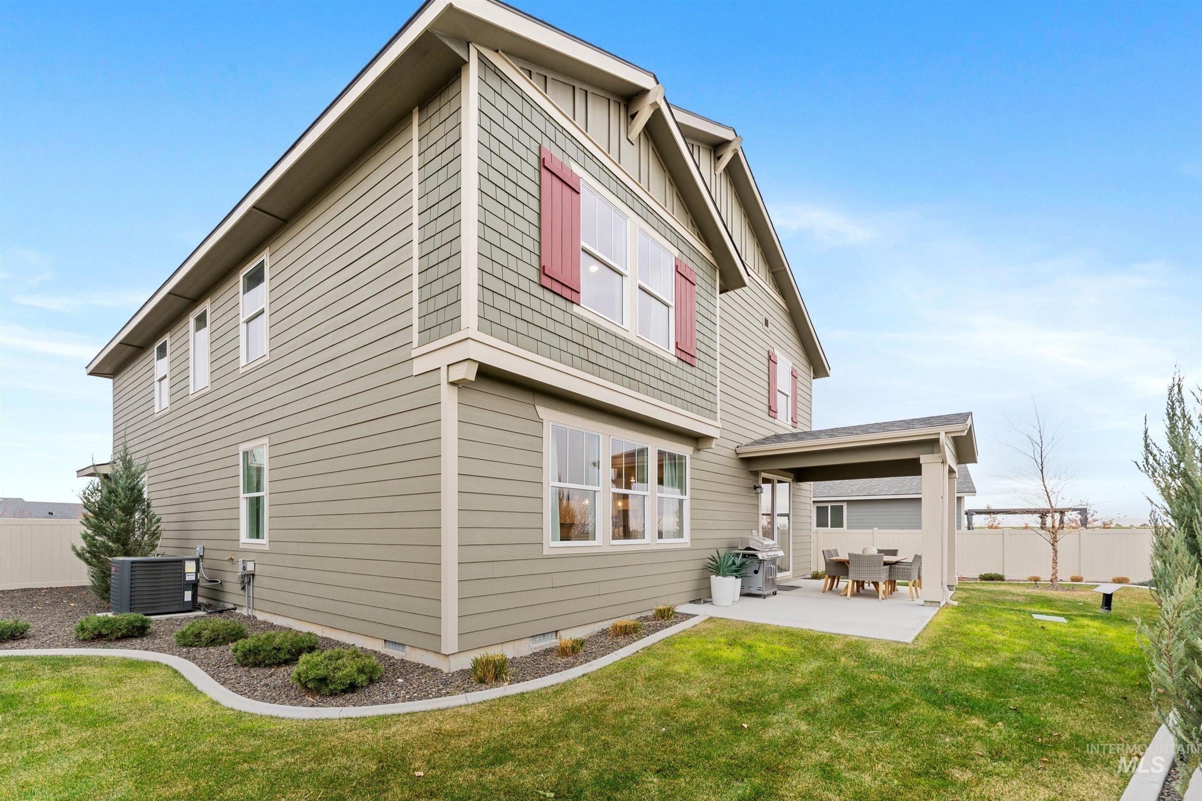 Back of house featuring a fenced backyard, crawl space, a patio, and board and batten siding