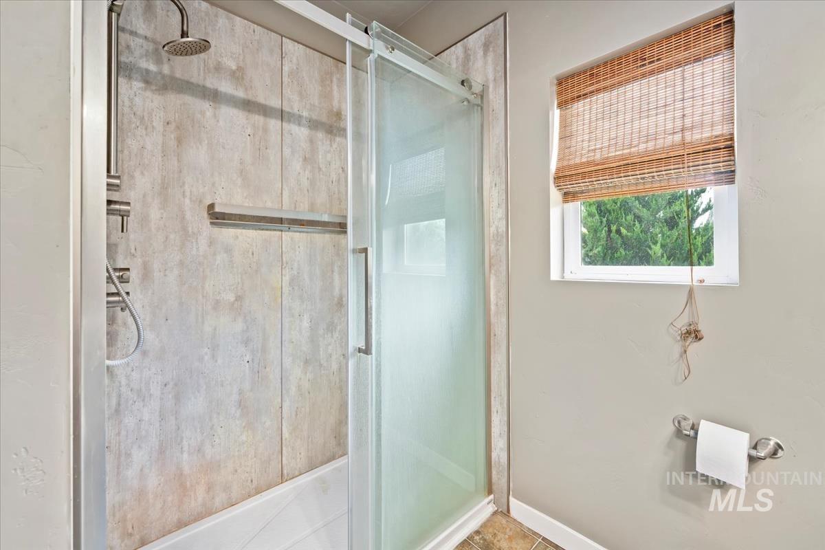 Bathroom with a stall shower and tile patterned floors