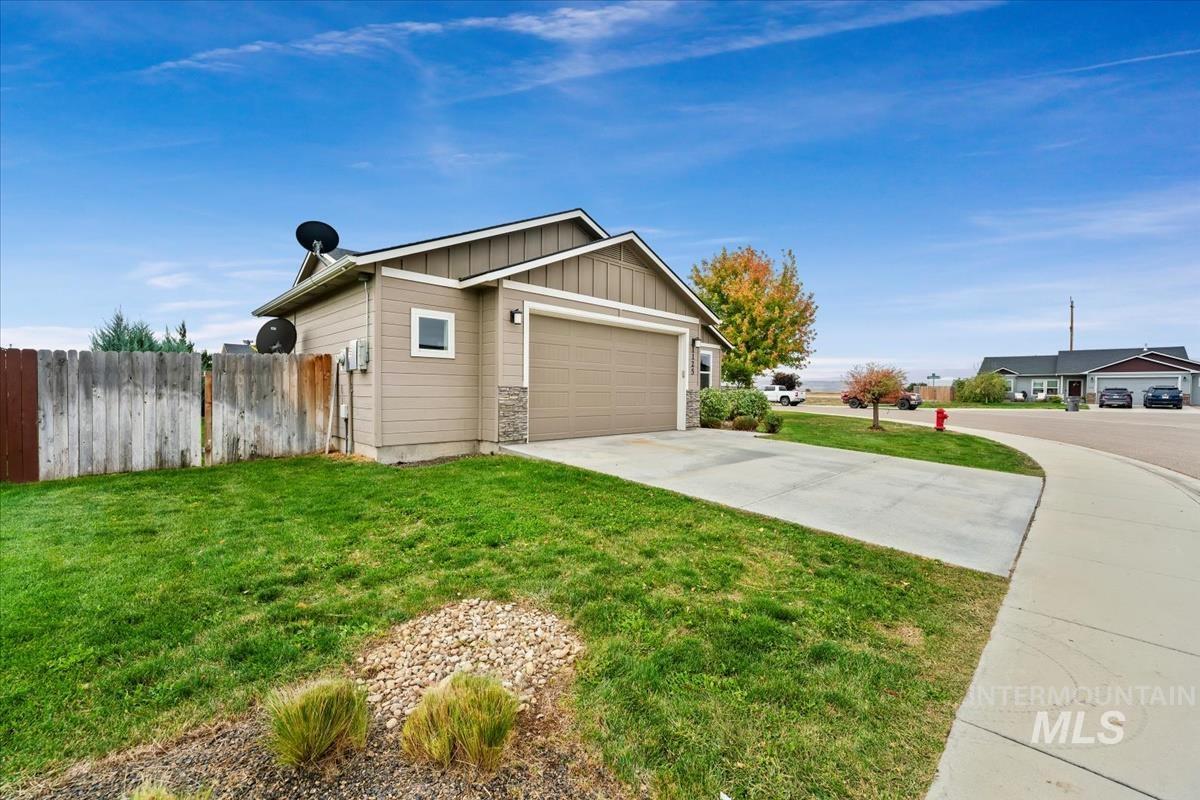 View of side of home with board and batten siding, driveway, and an attached garage