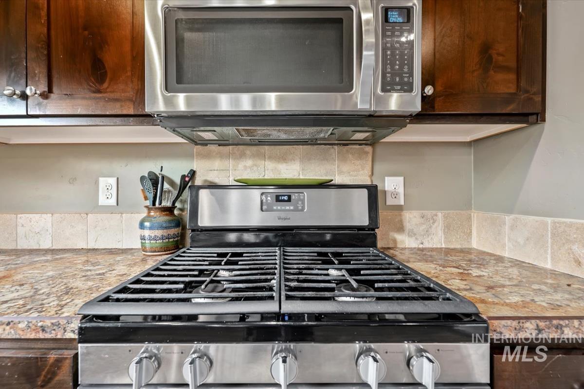 Kitchen view of stainless steel appliances and dark brown cabinets