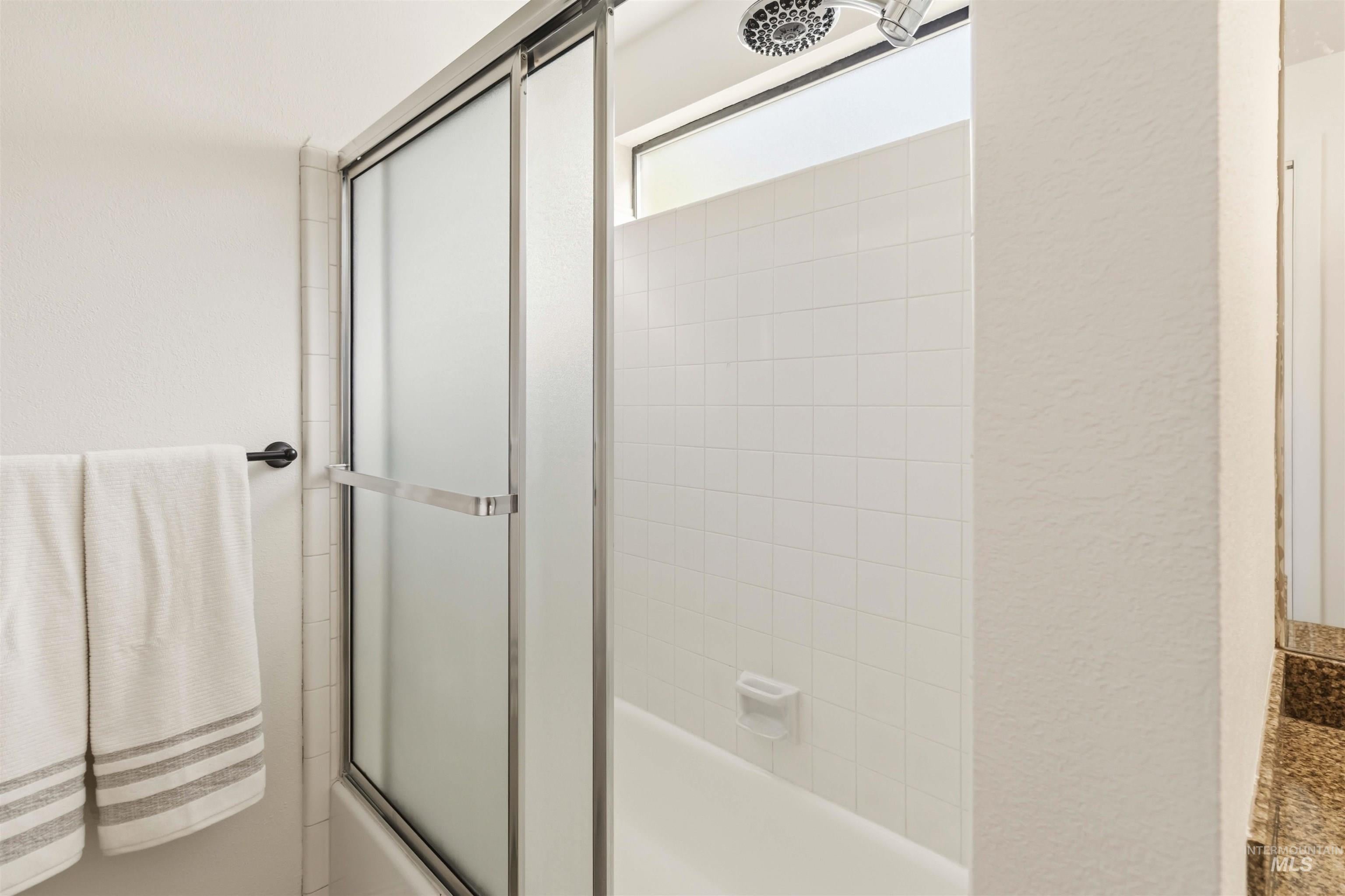 Shower-over-tub combination with sliding frosted glass enclosure