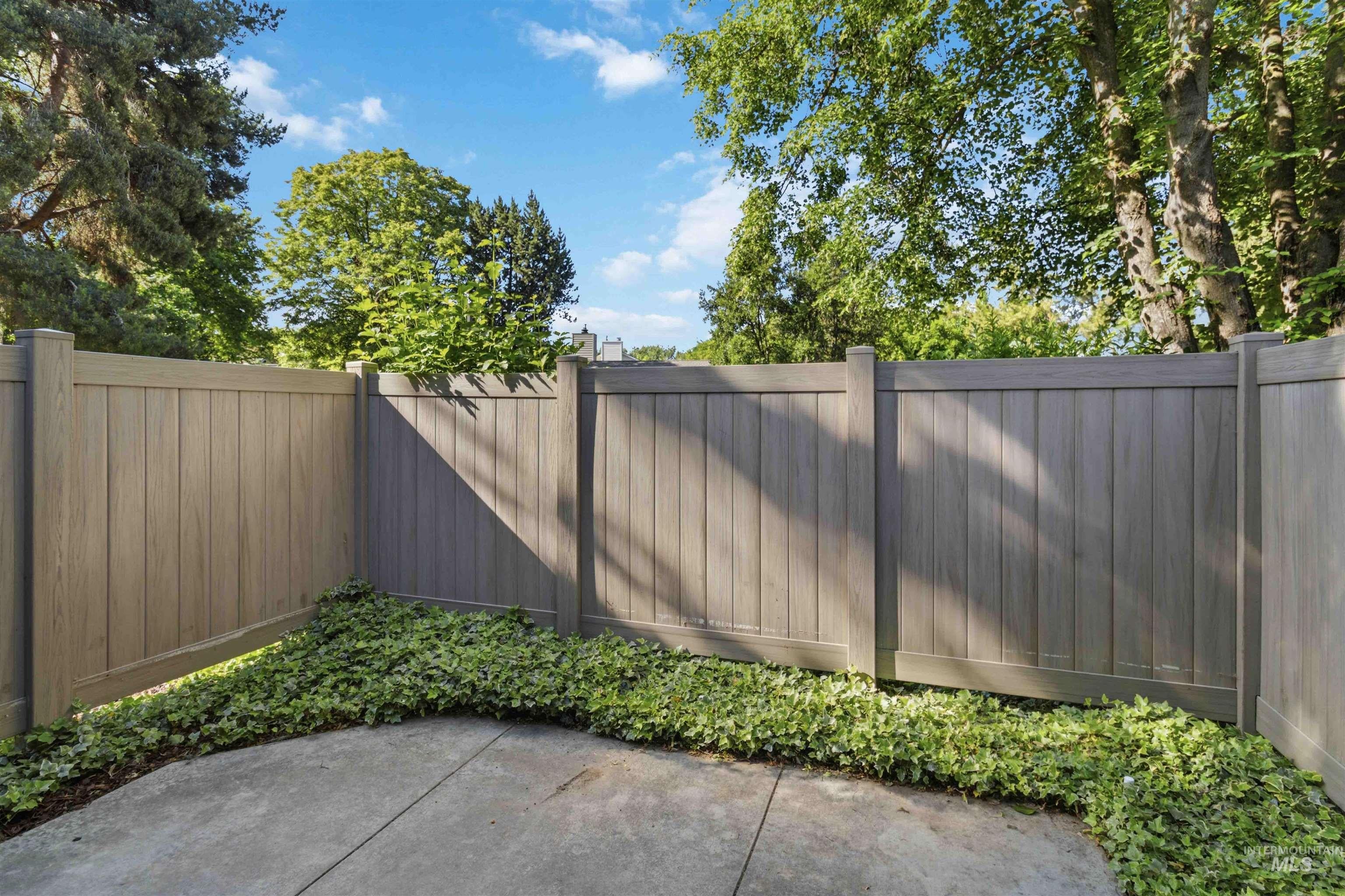 Concrete patio area featuring a composite privacy fence