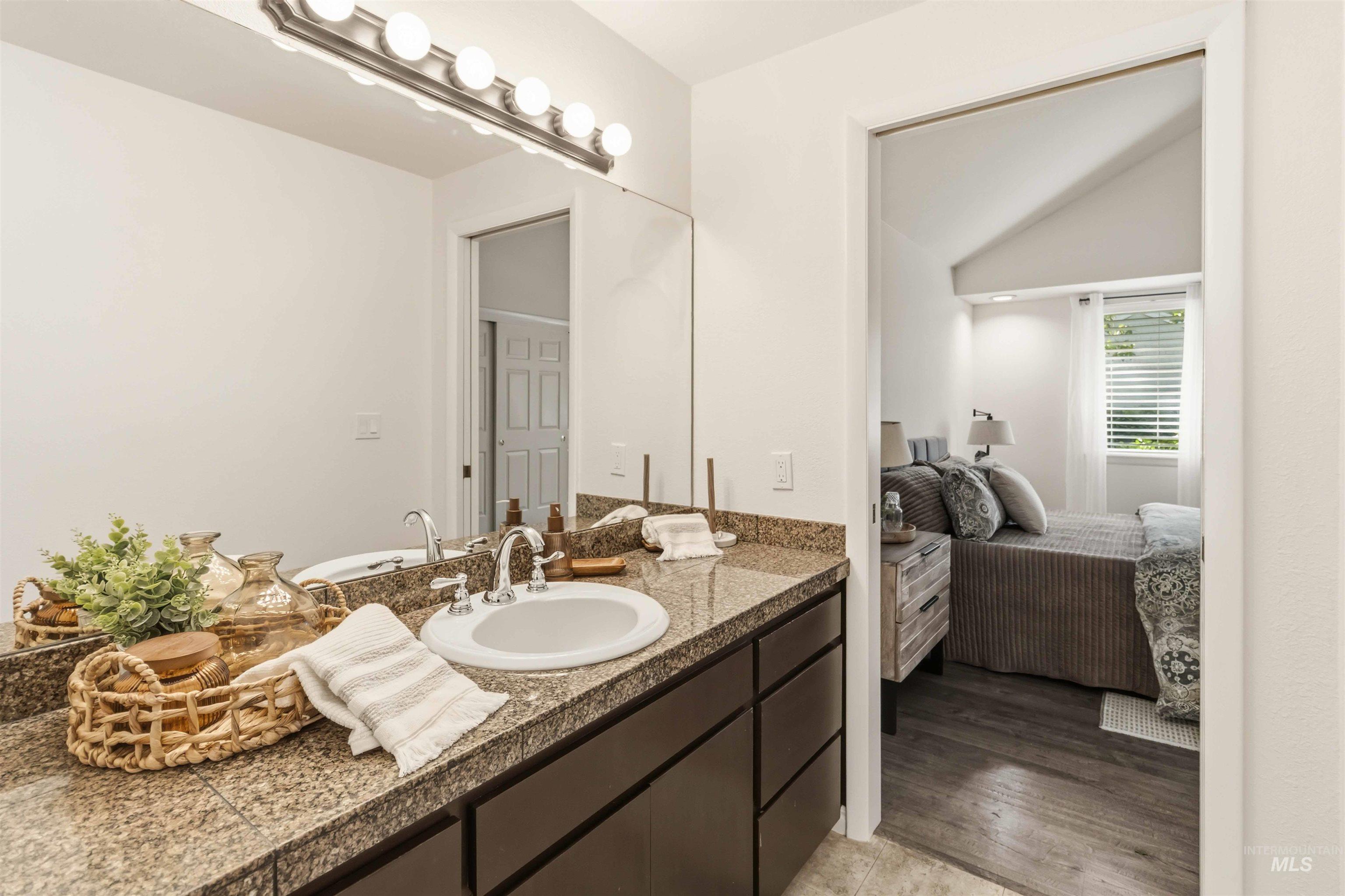 Bathroom vanity featuring dual undermount sinks, a granite countertop, and dark wood cabinetry
