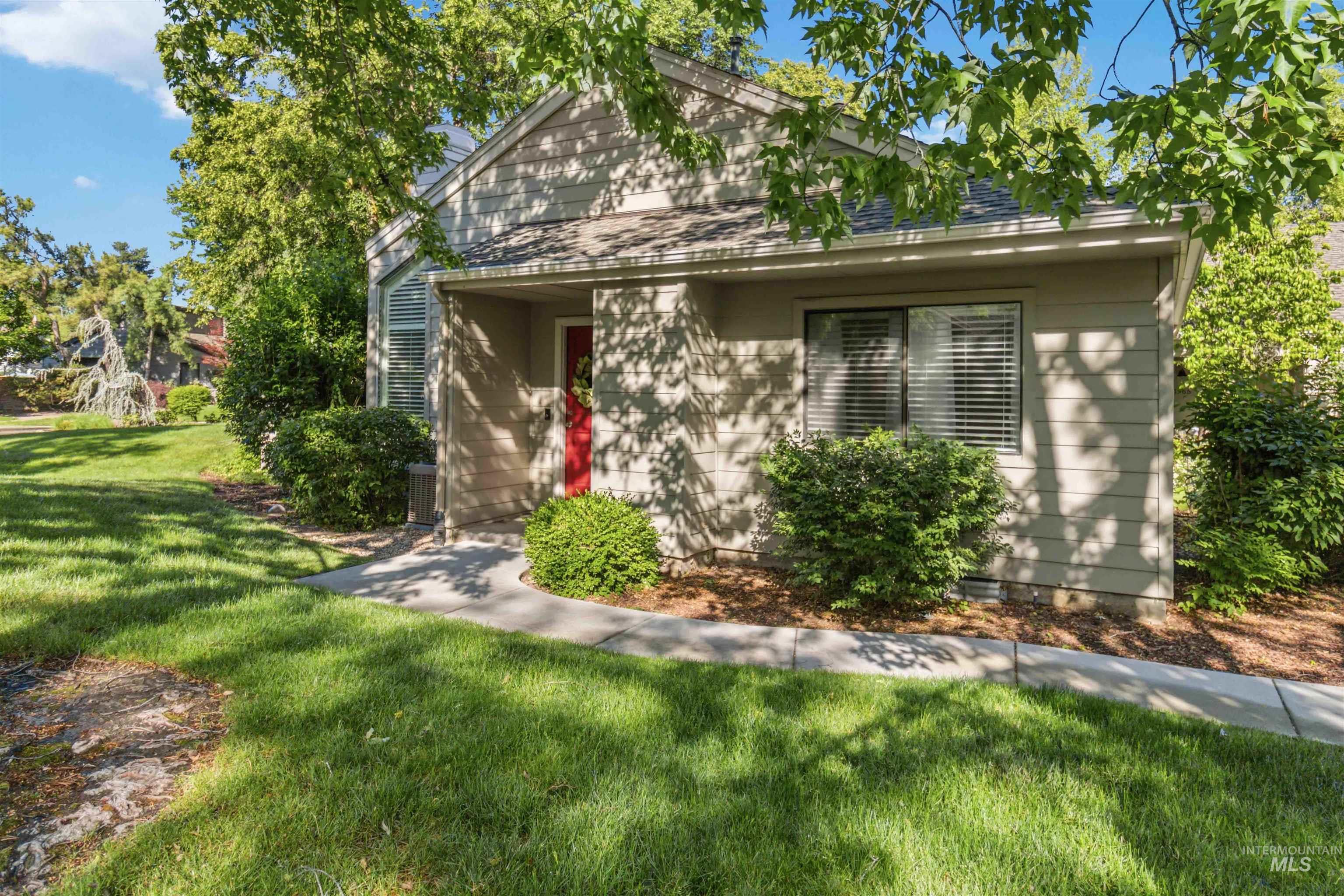 Exterior featuring horizontal siding, a prominent red entry door, and an integrated covered entry