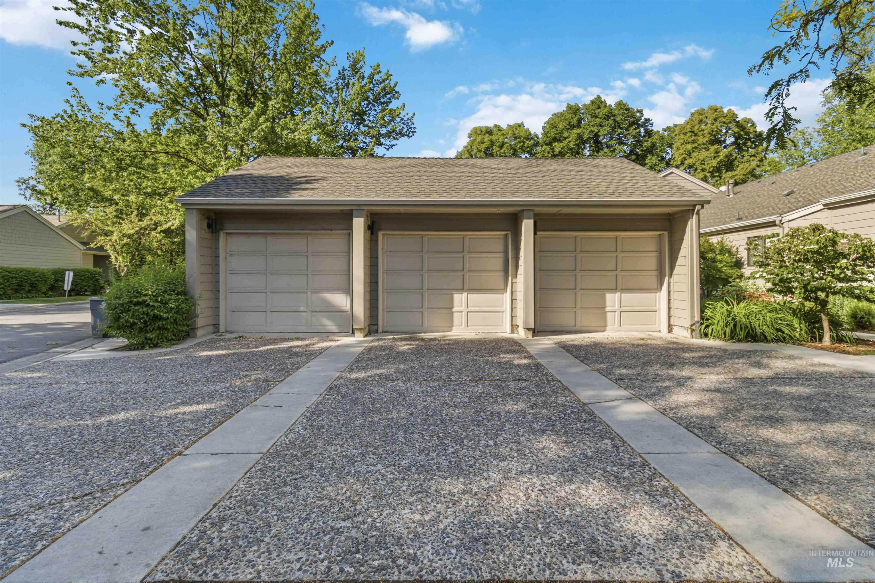 Three individual garage bays with light-colored sectional doors