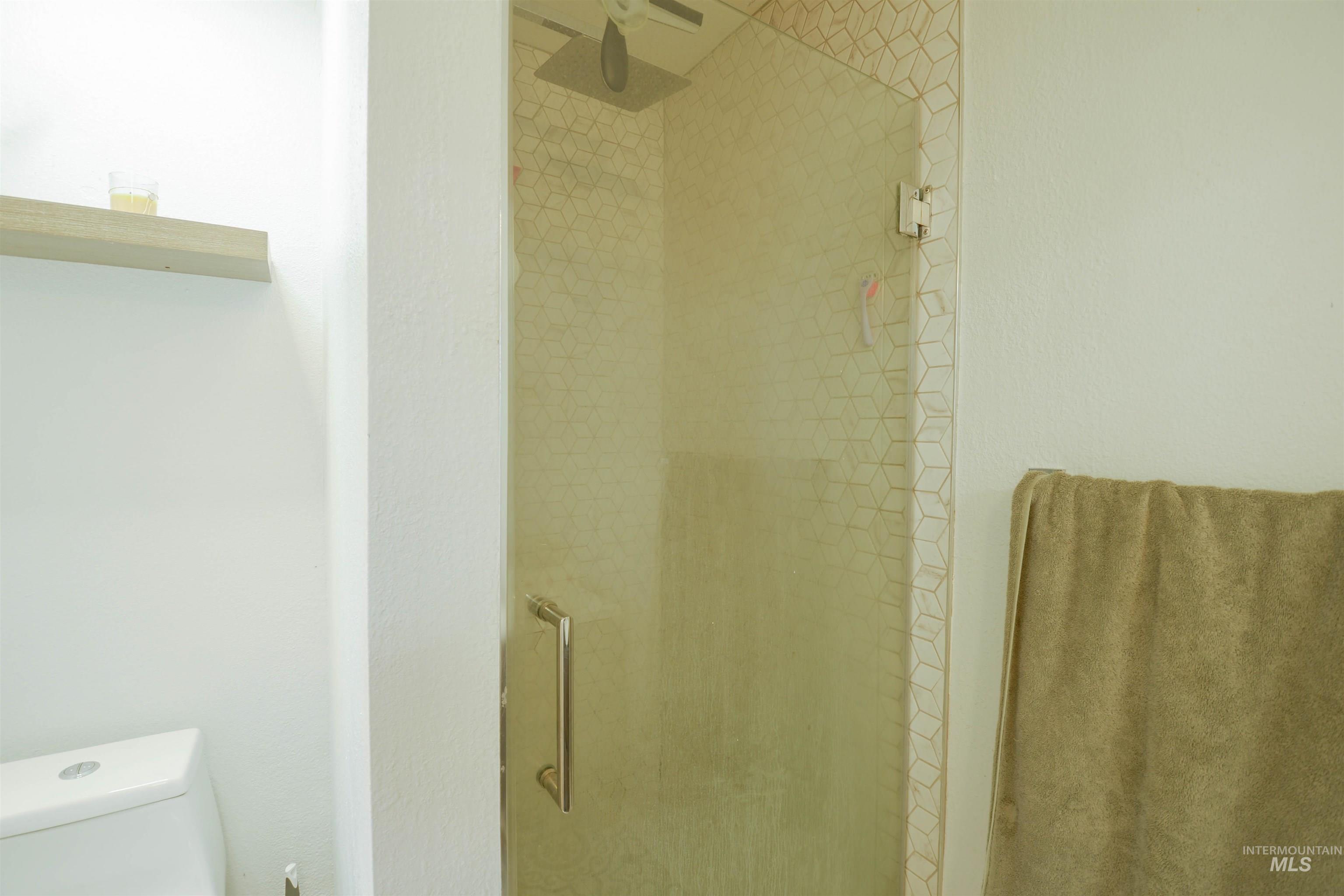 Full bathroom with a stall shower and toilet