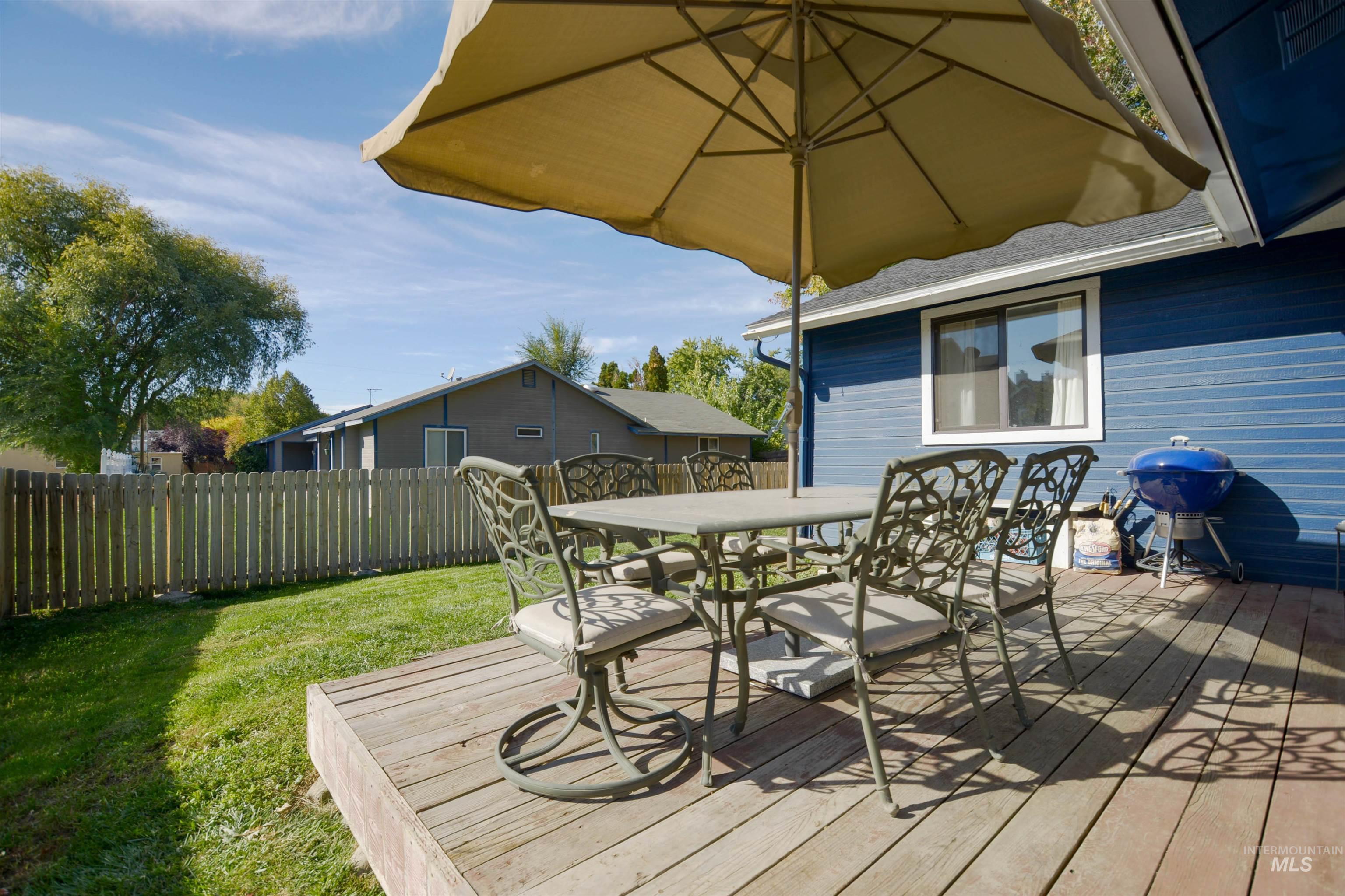 Wooden deck featuring outdoor dining space, a fenced backyard, and area for grilling