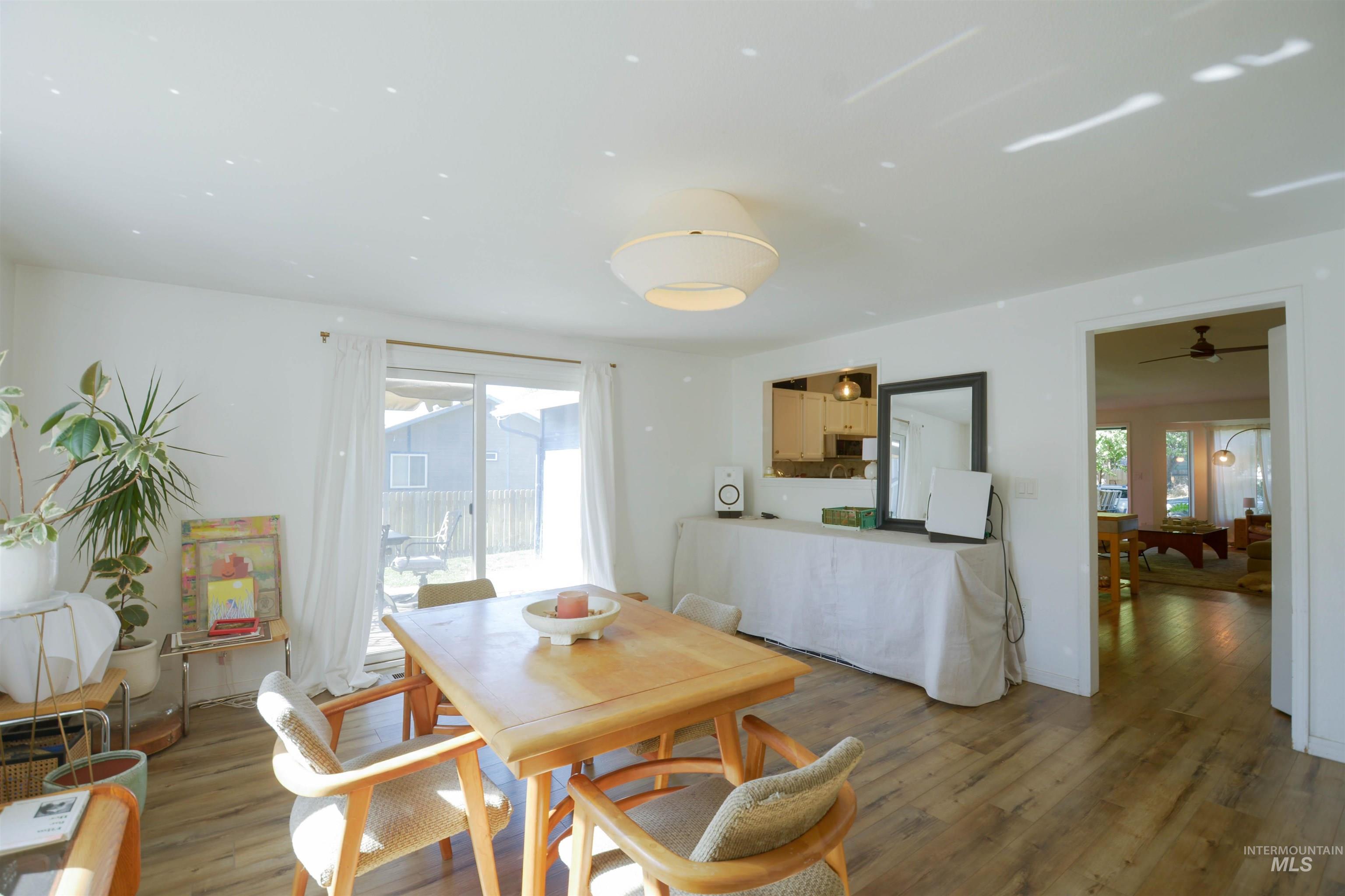 Dining space with wood finished floors and ceiling fan