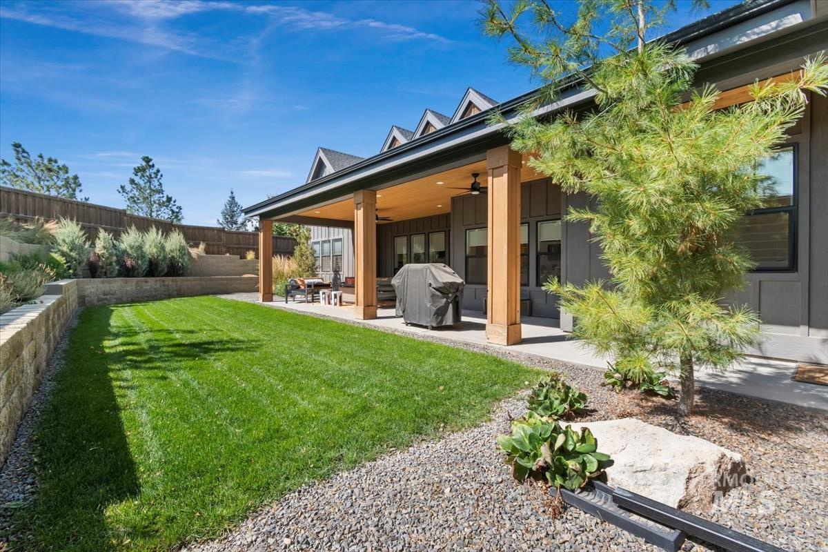 Back of house with a patio area, a fenced backyard, board and batten siding, and ceiling fan
