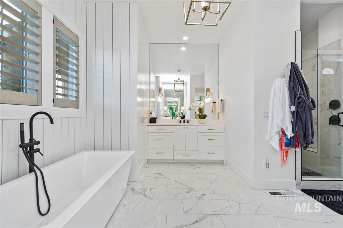Bathroom featuring a chandelier, a marble finish shower, light marble finish flooring, and recessed lighting