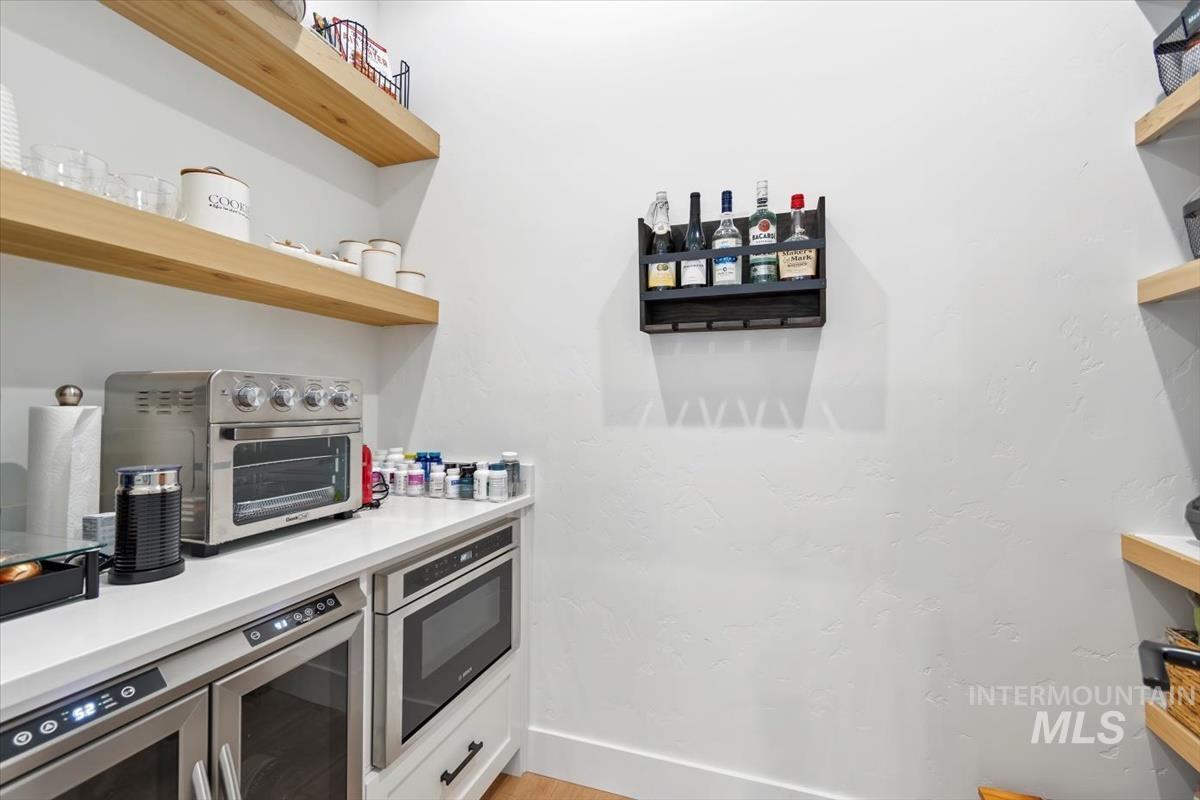 Kitchen with open shelves and stainless steel microwave