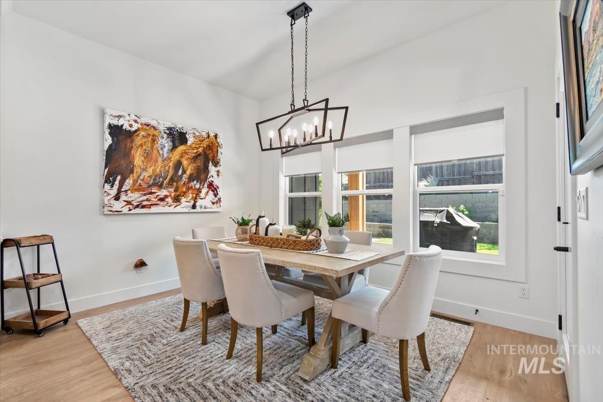 Dining area with light wood finished floors and a chandelier