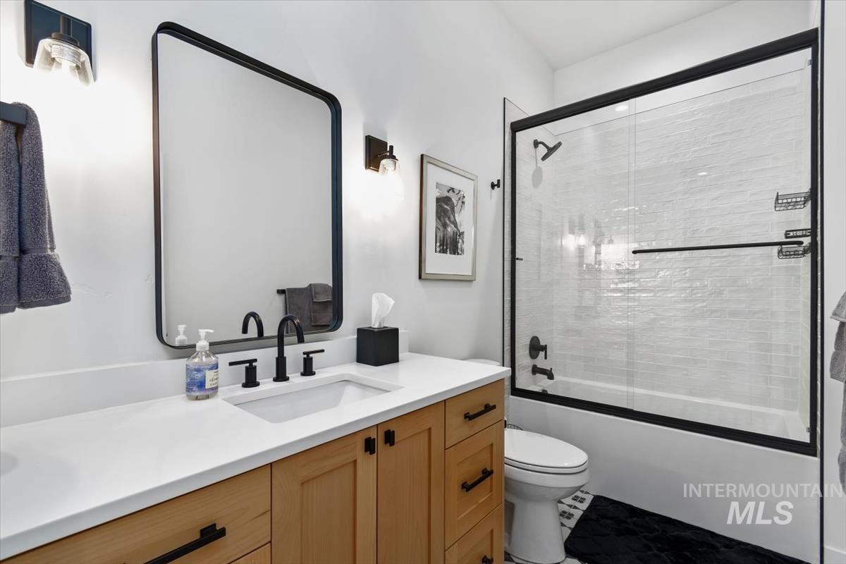 Full bathroom with vanity and bath / shower combo with glass door