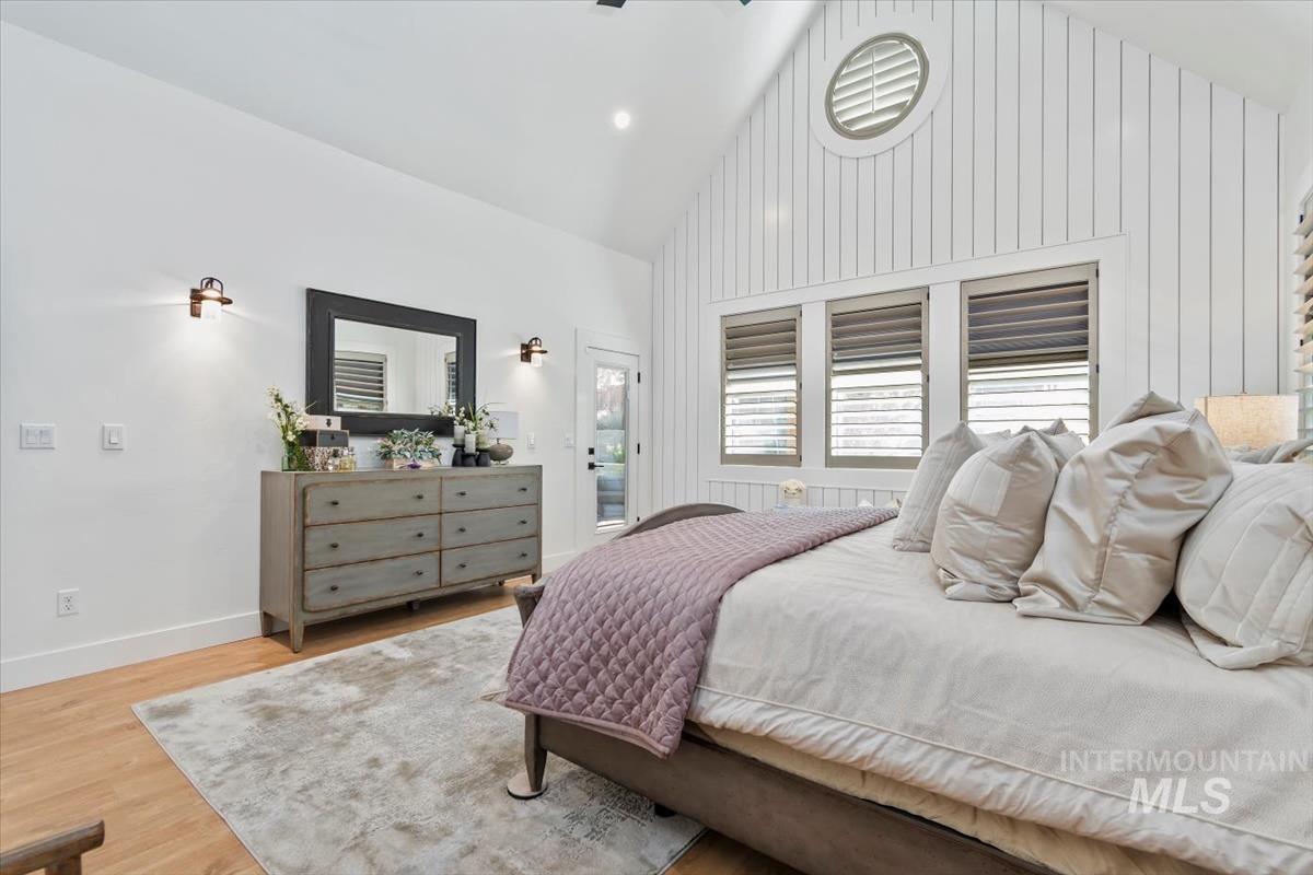Bedroom featuring high vaulted ceiling, wood finished floors, access to exterior, and recessed lighting