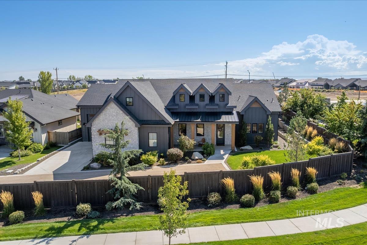 Modern farmhouse featuring board and batten siding, stone siding, a residential view, and covered porch