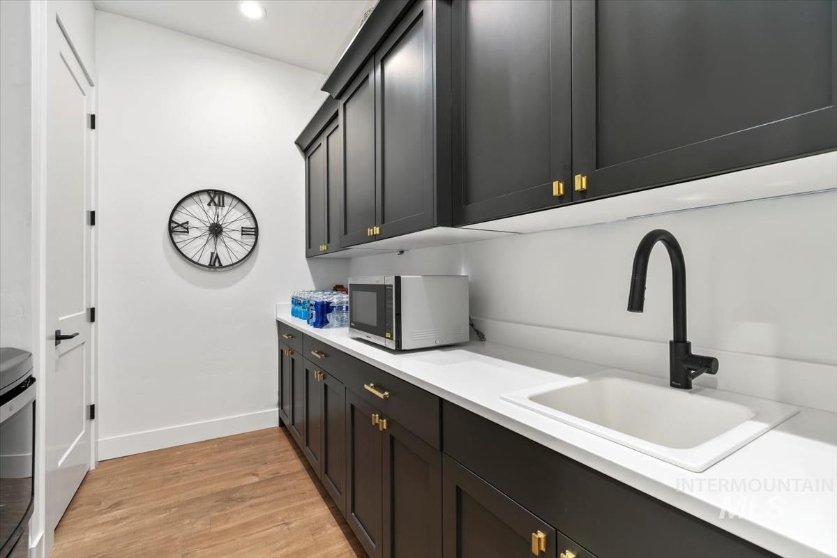 Laundry room with light wood-style flooring and recessed lighting