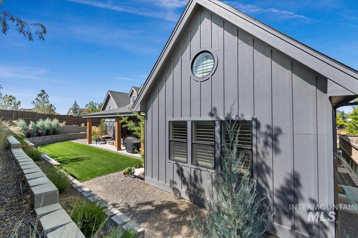 View of property exterior with a patio area and board and batten siding