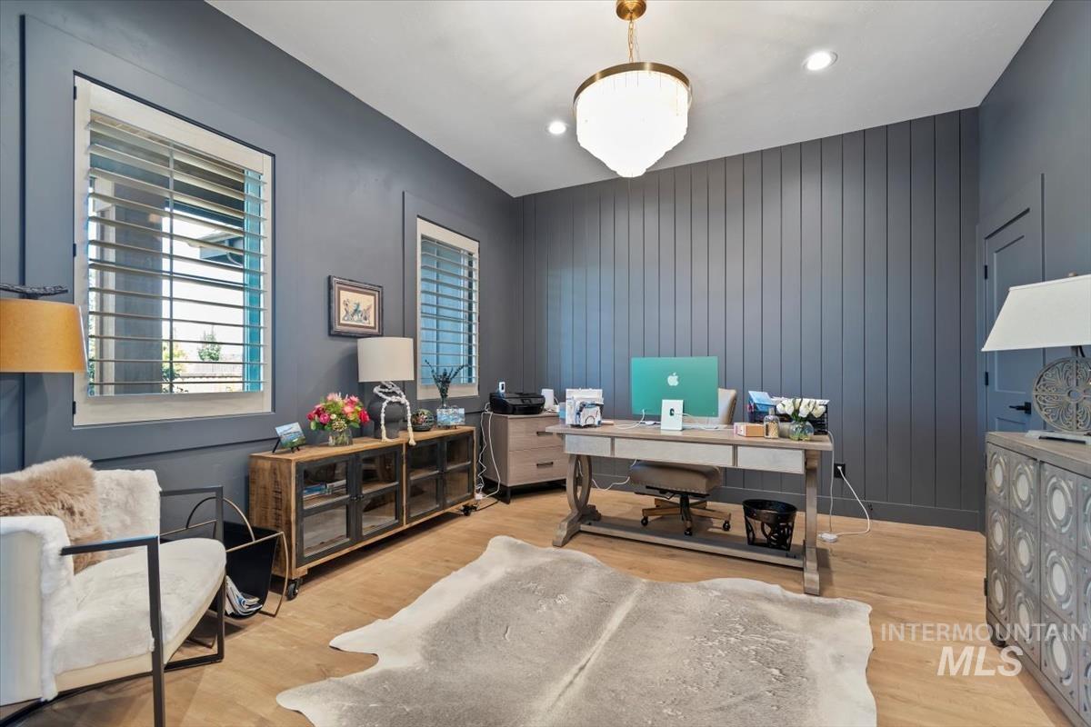 Office area featuring light wood-style floors, wood walls, and recessed lighting