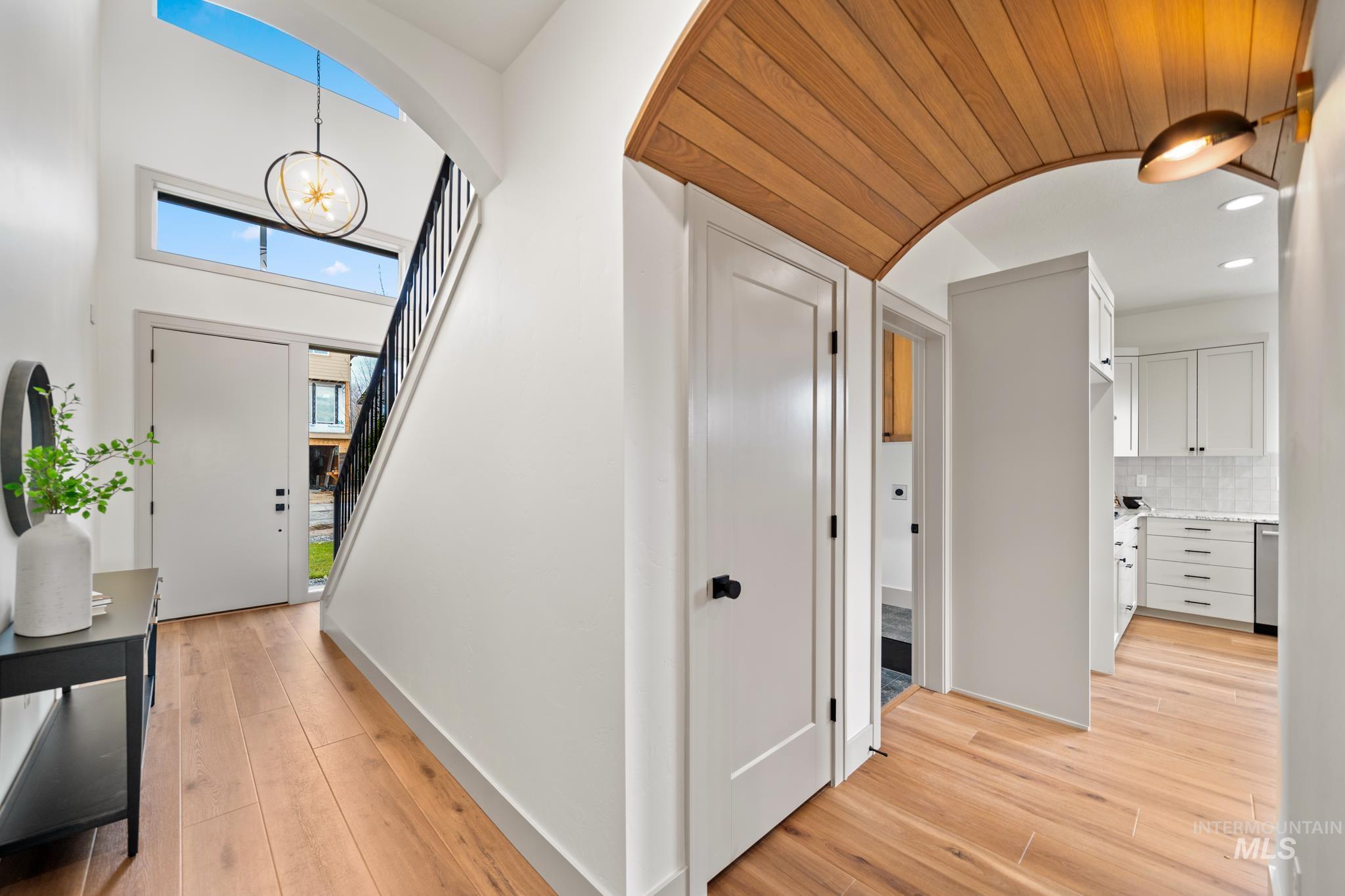Foyer entrance featuring light wood-style flooring, a chandelier, arched walkways, and recessed lighting