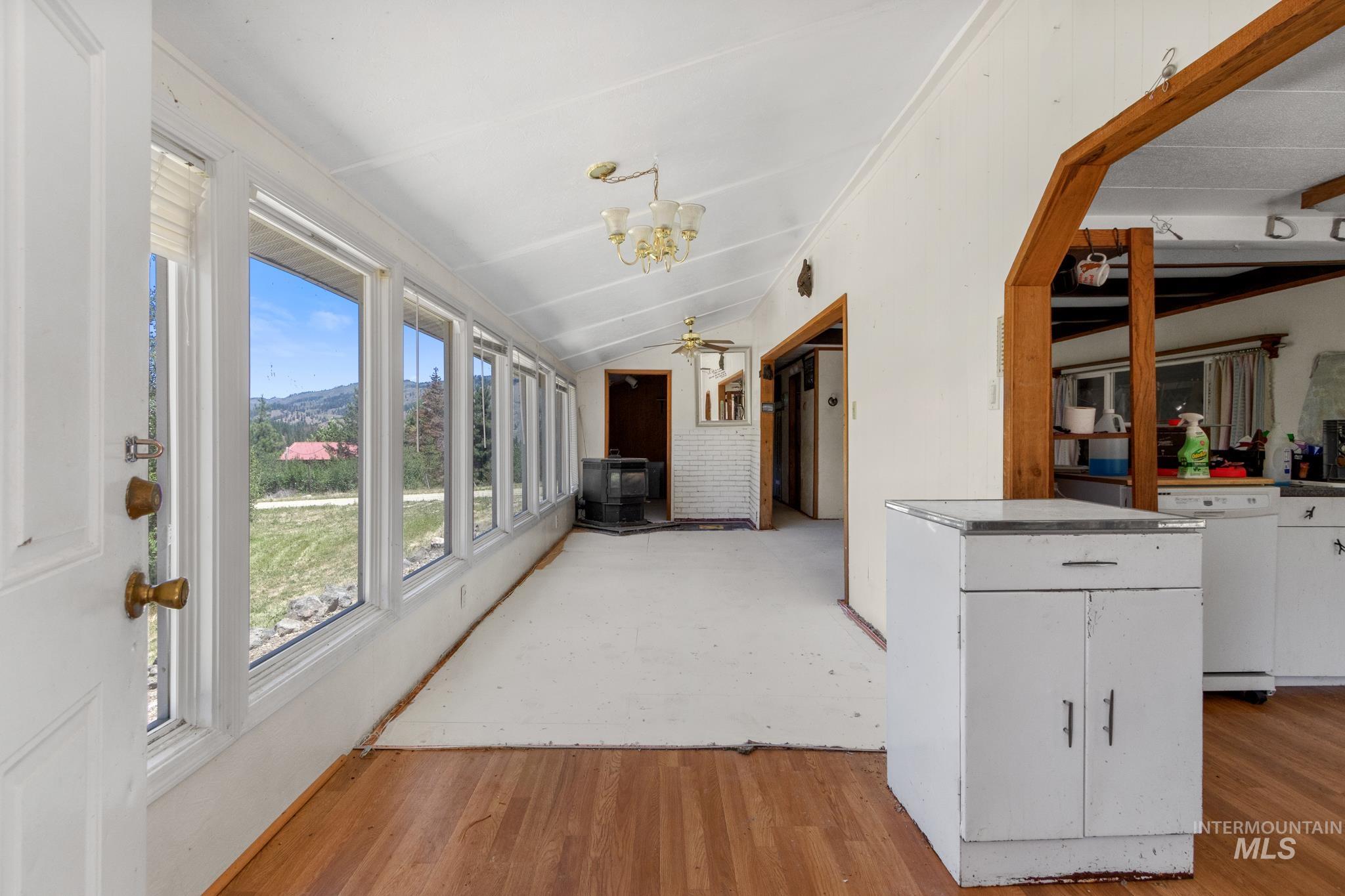 Sunroom featuring multiple large windows, a sloped ceiling, and wood-finish flooring