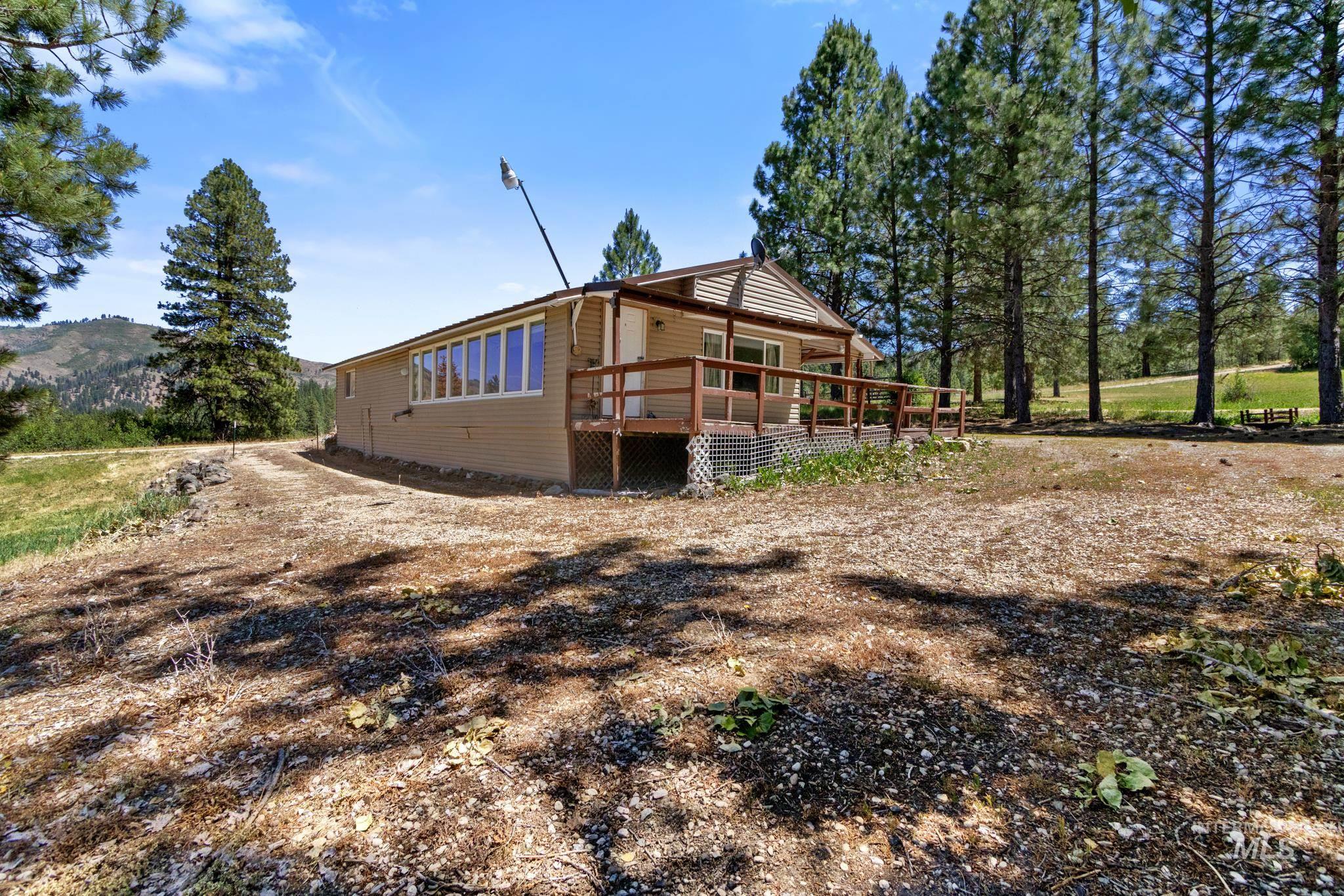 Ranch-style exterior with beige siding, a covered deck, and a full-length bank of windows