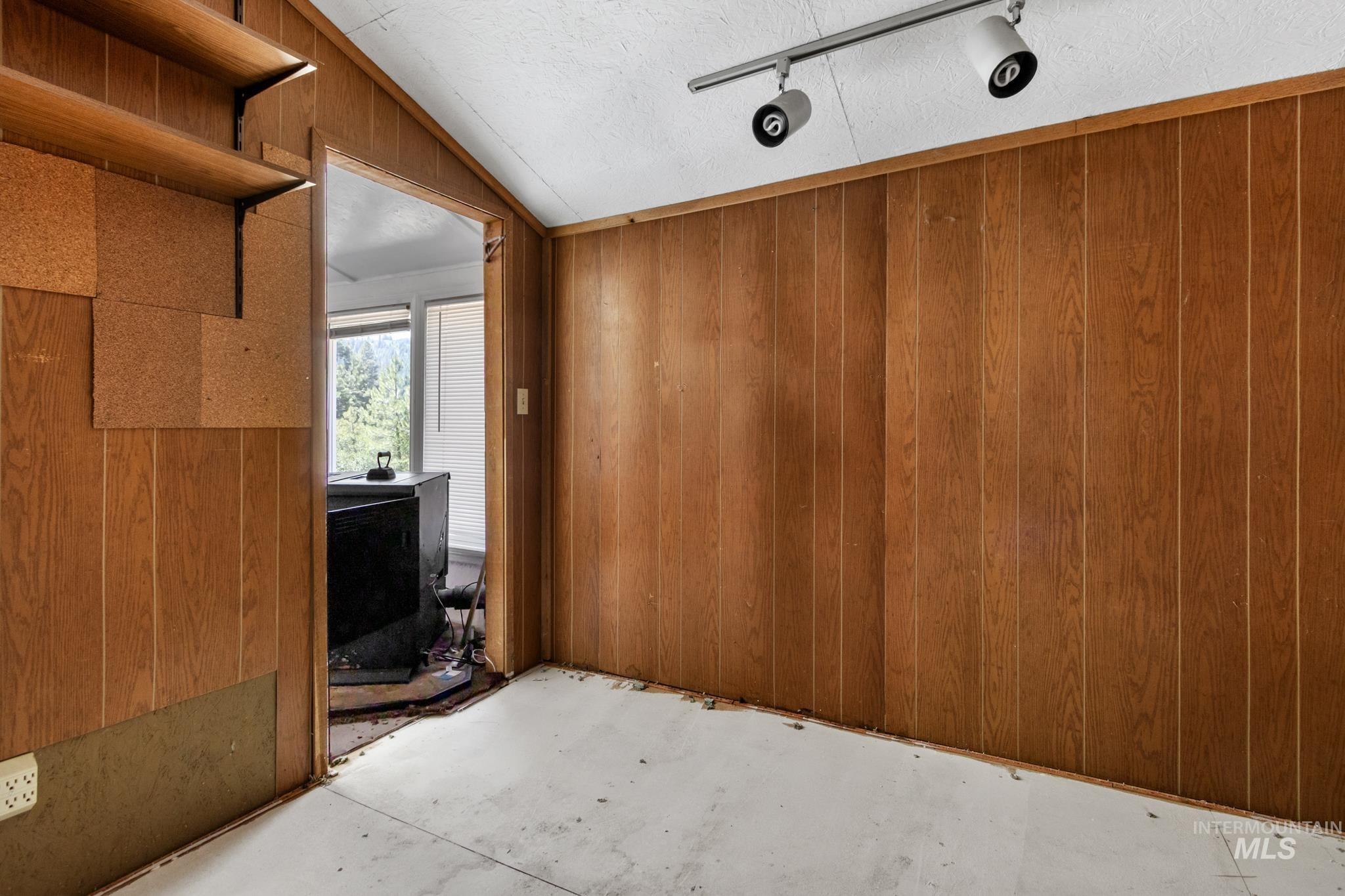 Interior room with wood paneling walls and a track lighting fixture
