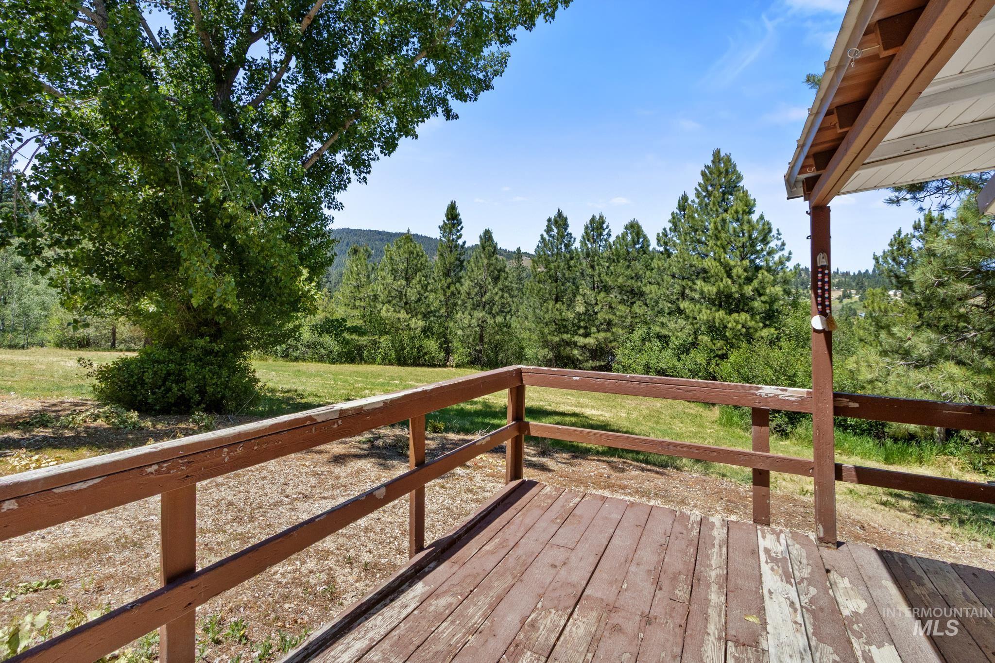 Wood deck with a brown railing overlooking a natural landscape