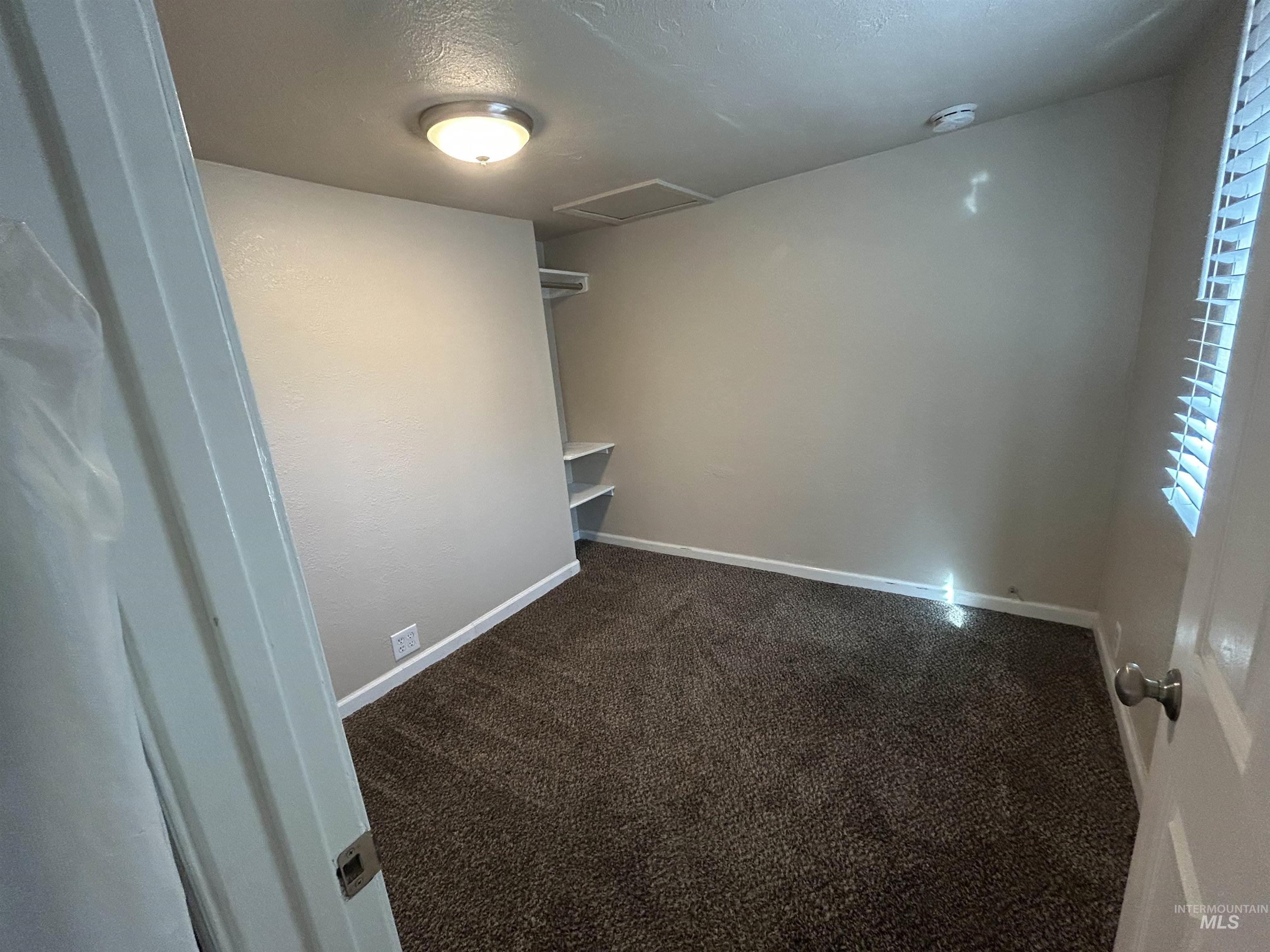 Secondary bedroom. Carpeted with good natural light and a small nook for storage.