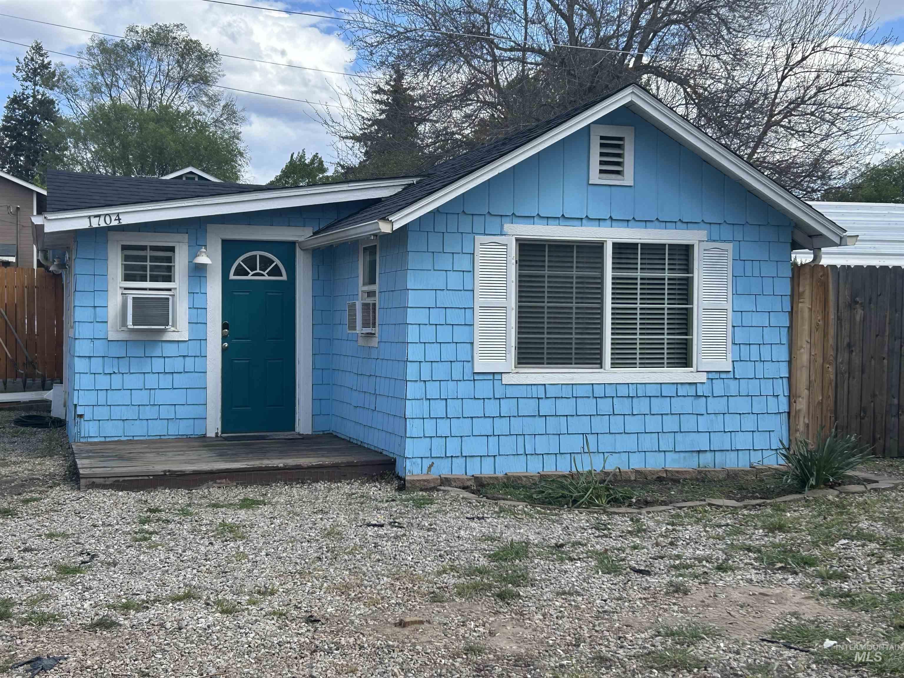 Blue shingle-style siding exterior with white window trim and shutters