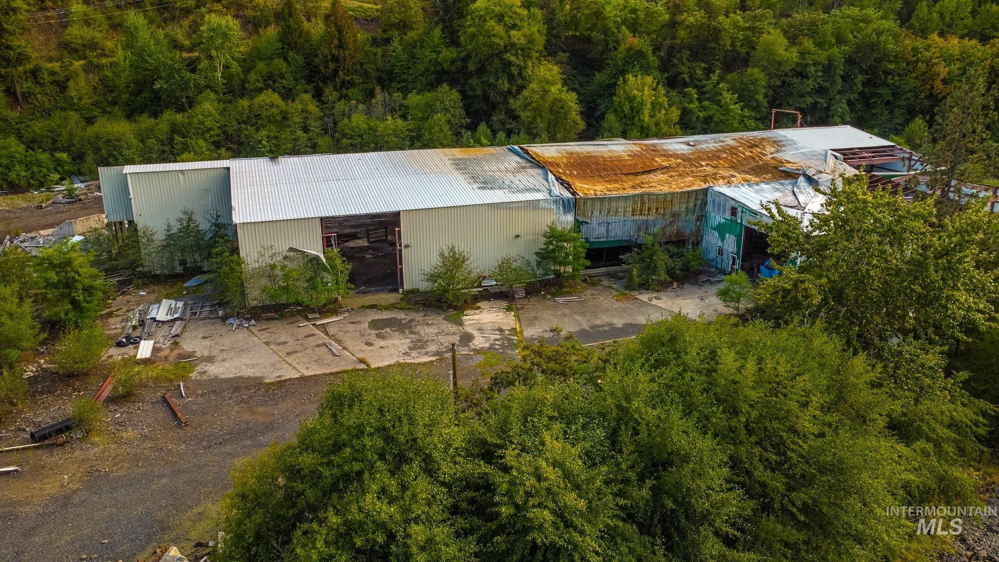 Aerial view of property and surrounding area with a heavily wooded area