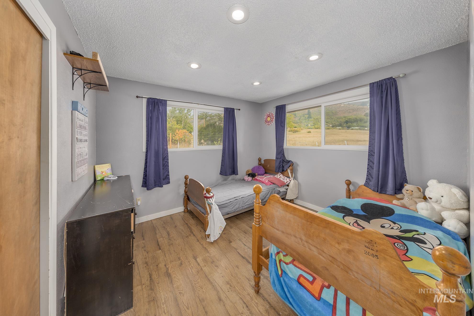 Bedroom featuring light wood-style floors, a textured ceiling, and recessed lighting