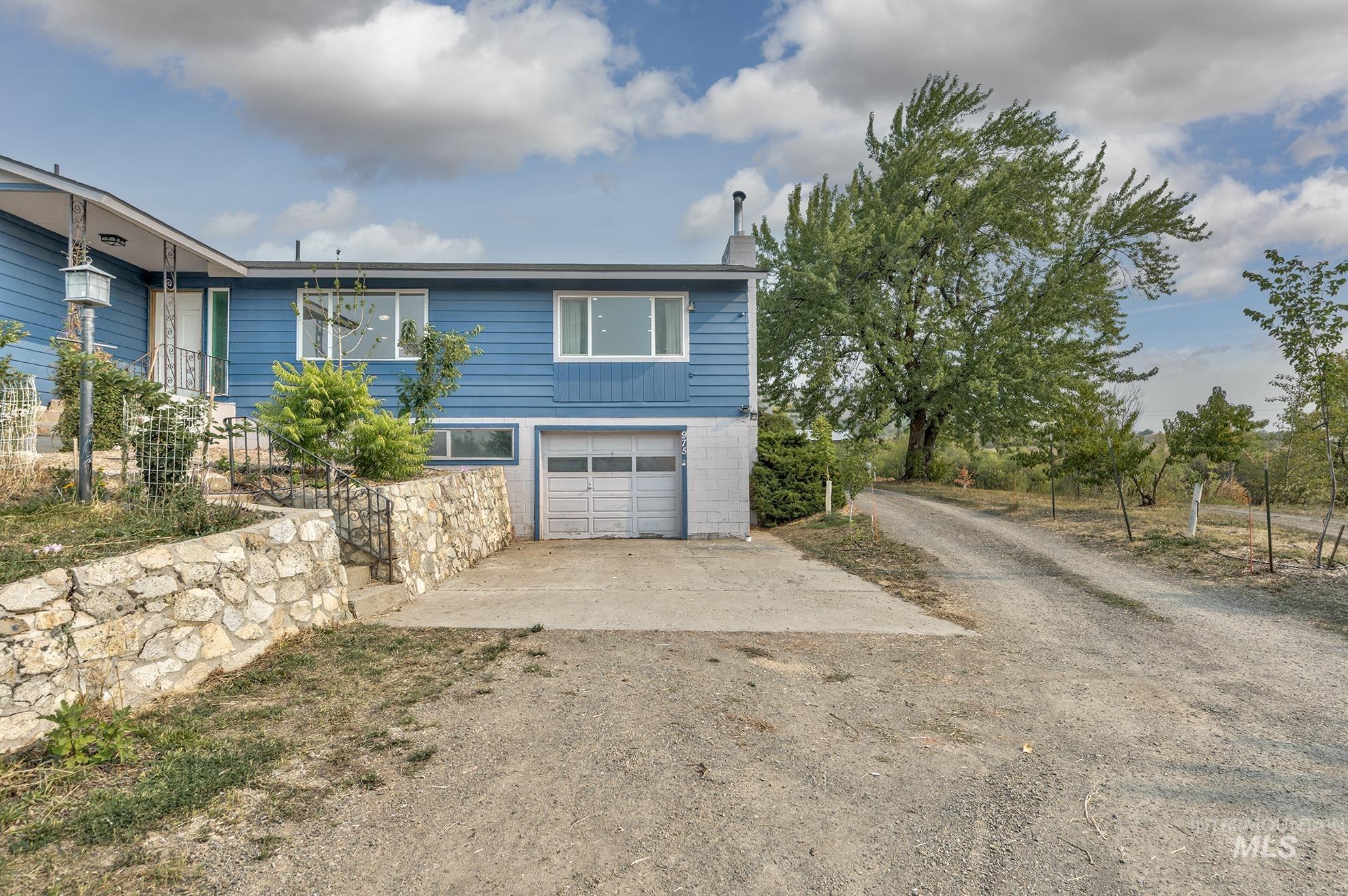 View of side of property with driveway and an attached garage