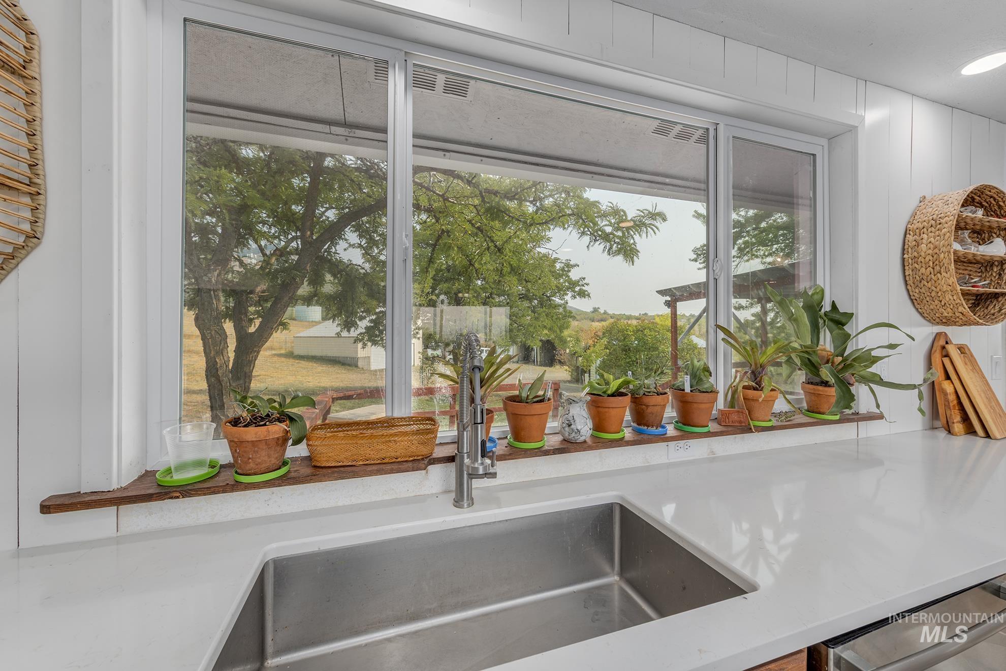 Kitchen view of light stone countertops and stainless steel dishwasher