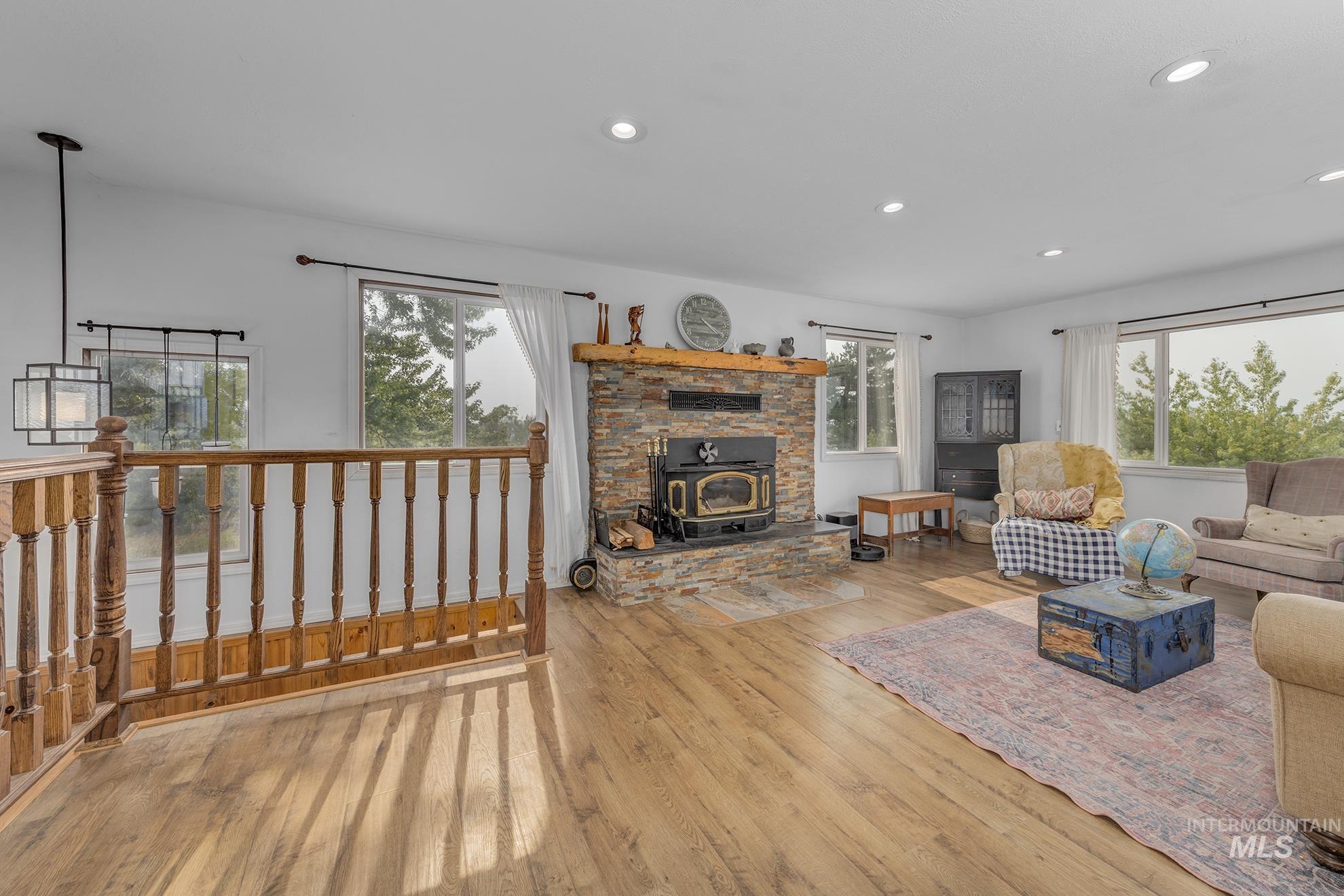 Living room featuring a wood stove, recessed lighting, and light wood-type flooring