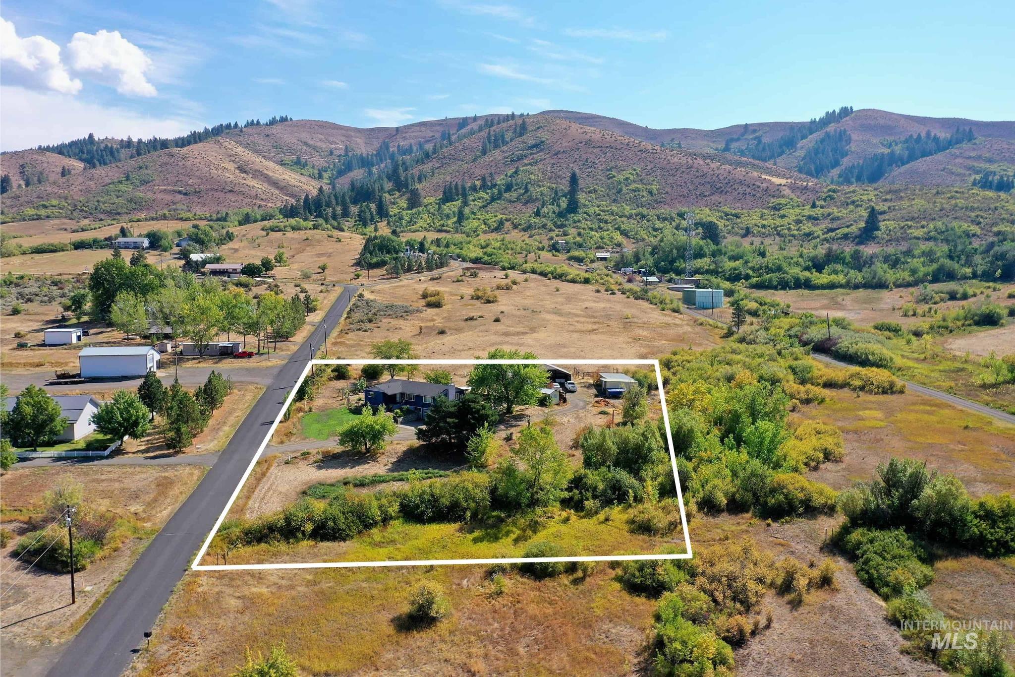 Overview of rural landscape with property parcel outlined and mountains