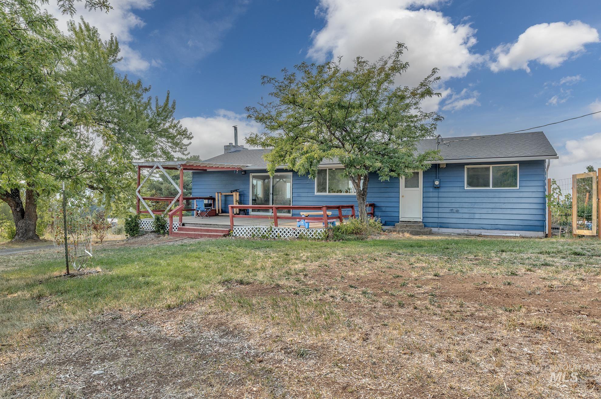 Rear view of house featuring a wooden deck and a lawn