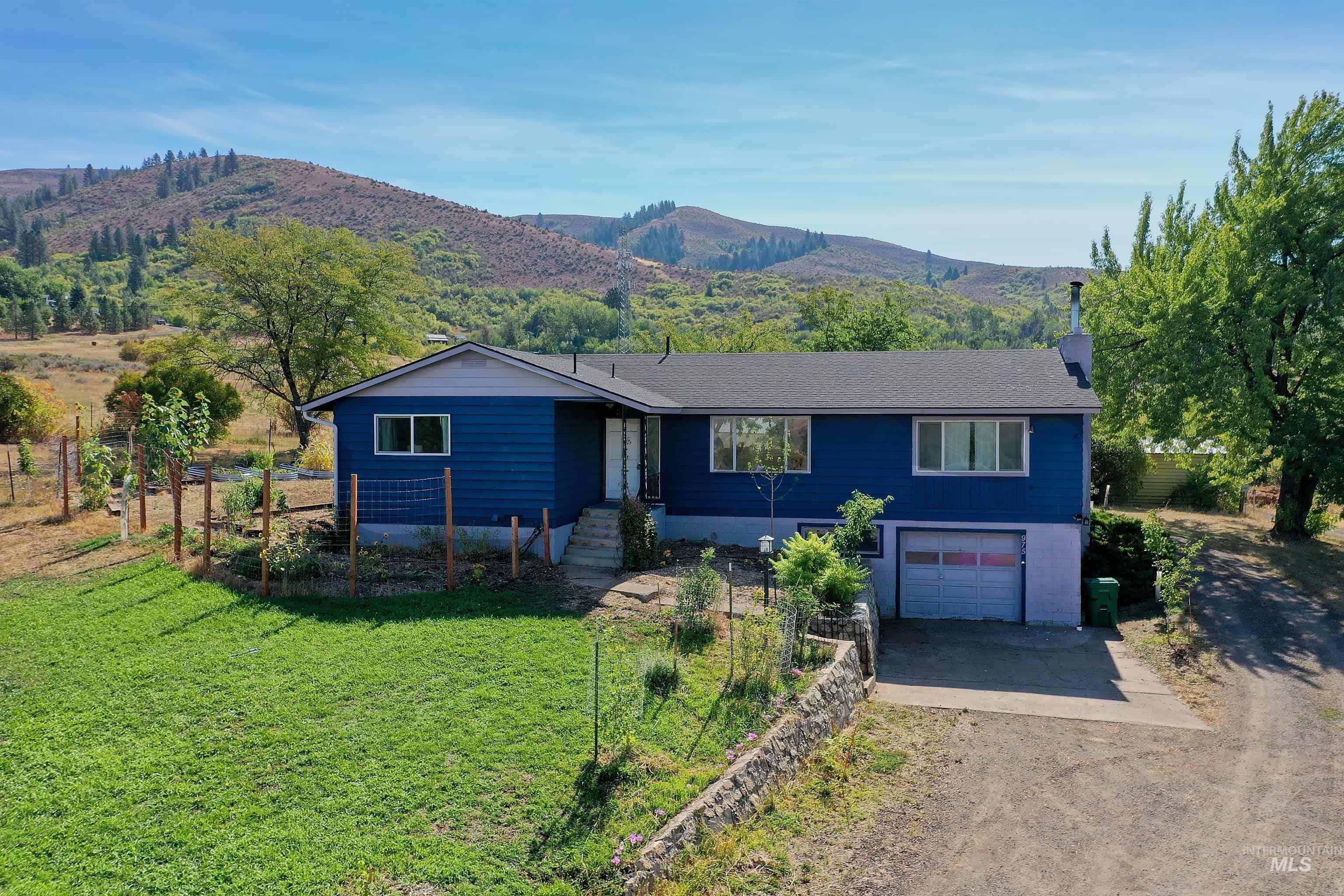 Single story home featuring driveway, a mountain view, and an attached garage