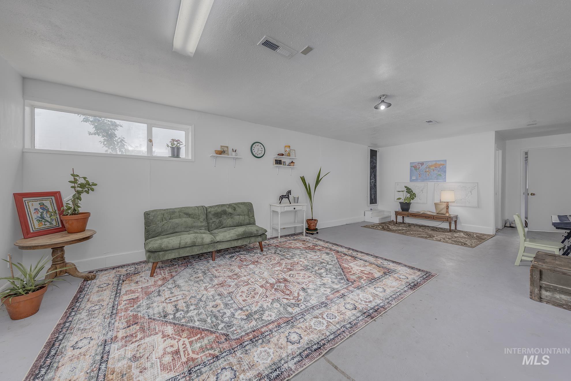 Living area featuring finished concrete flooring and baseboards
