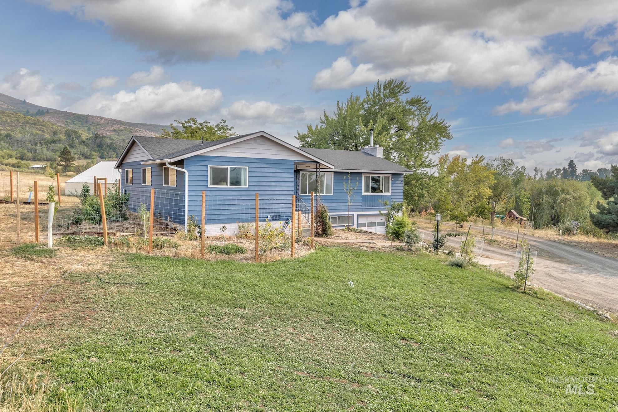 View of front facade with a chimney, a garage, and driveway